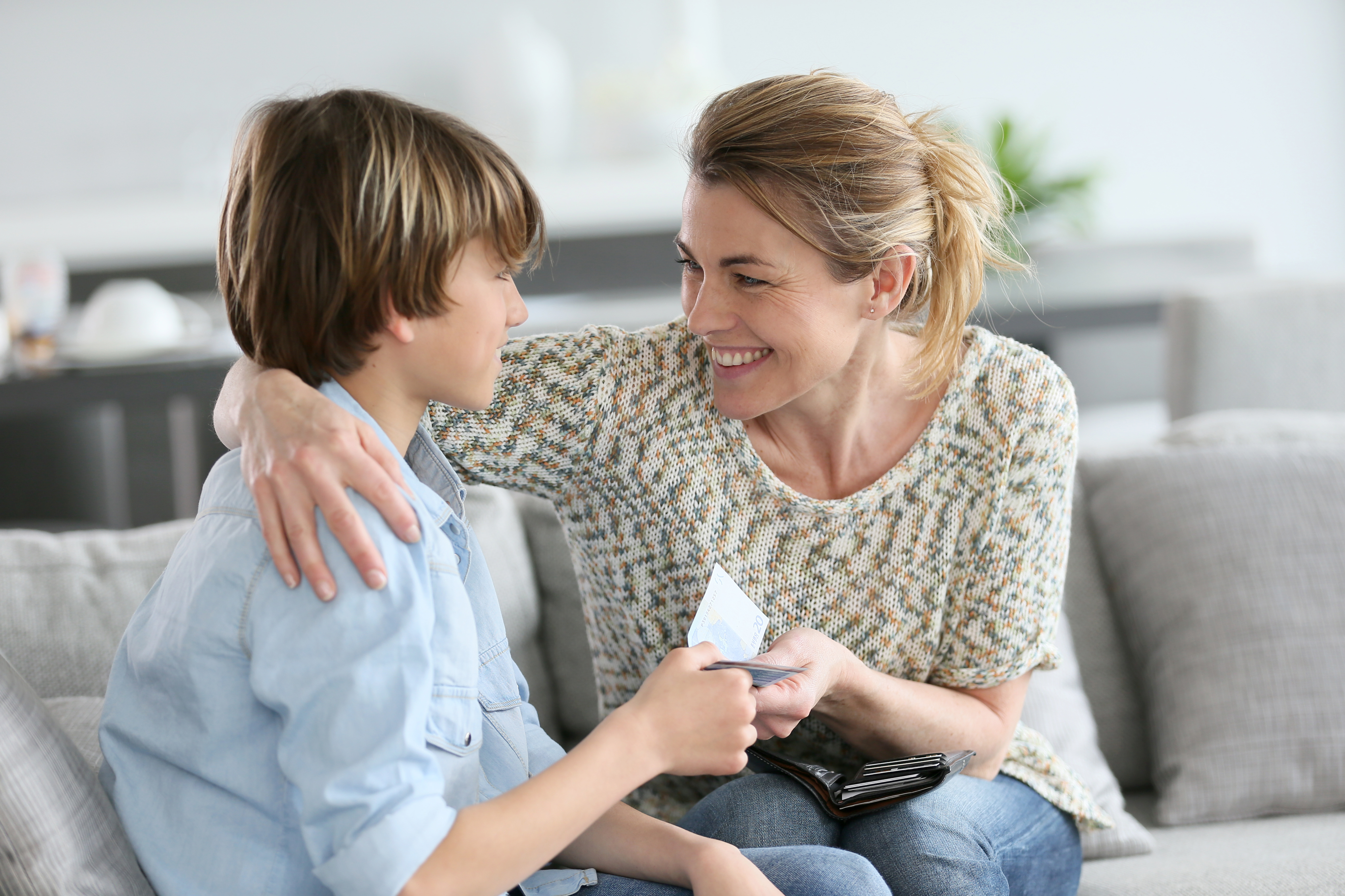A mother giving her son an allowance | Source: Shutterstock