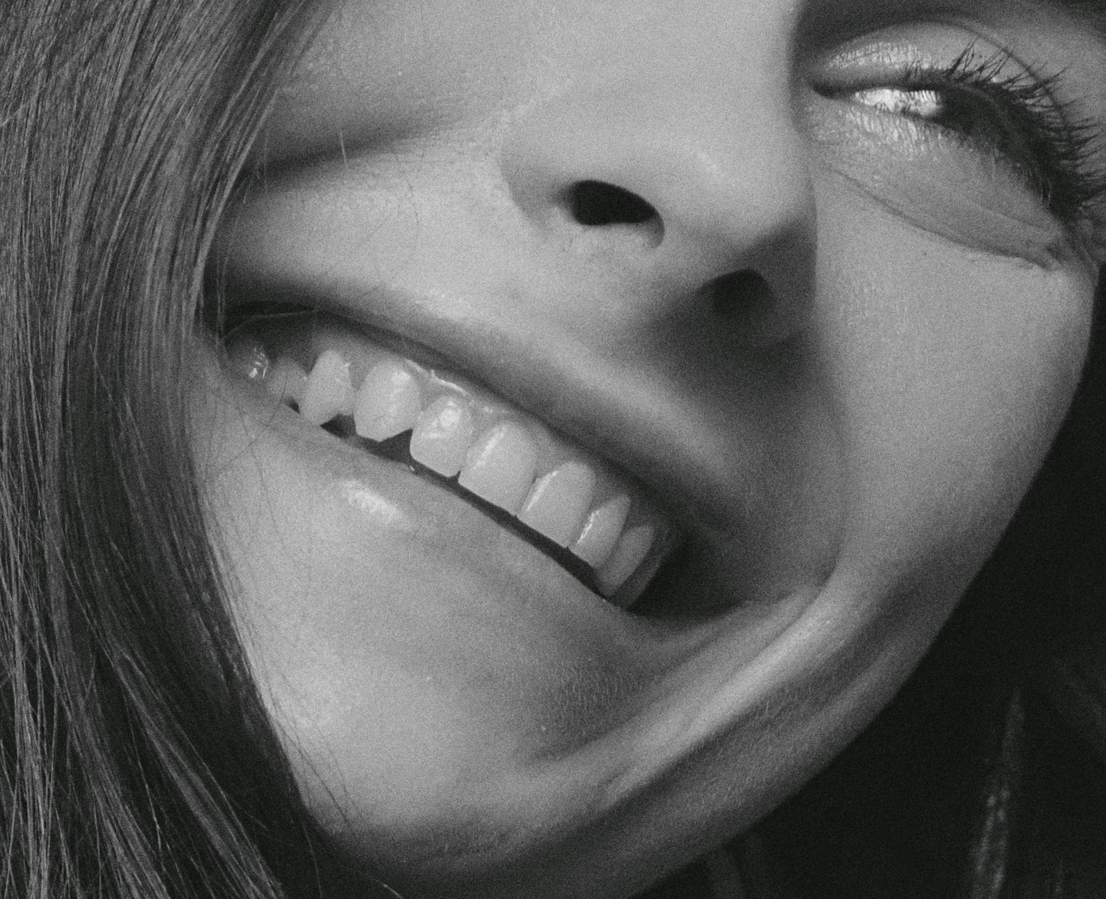 Close-up grayscale shot of a smiling woman | Source: Pexels