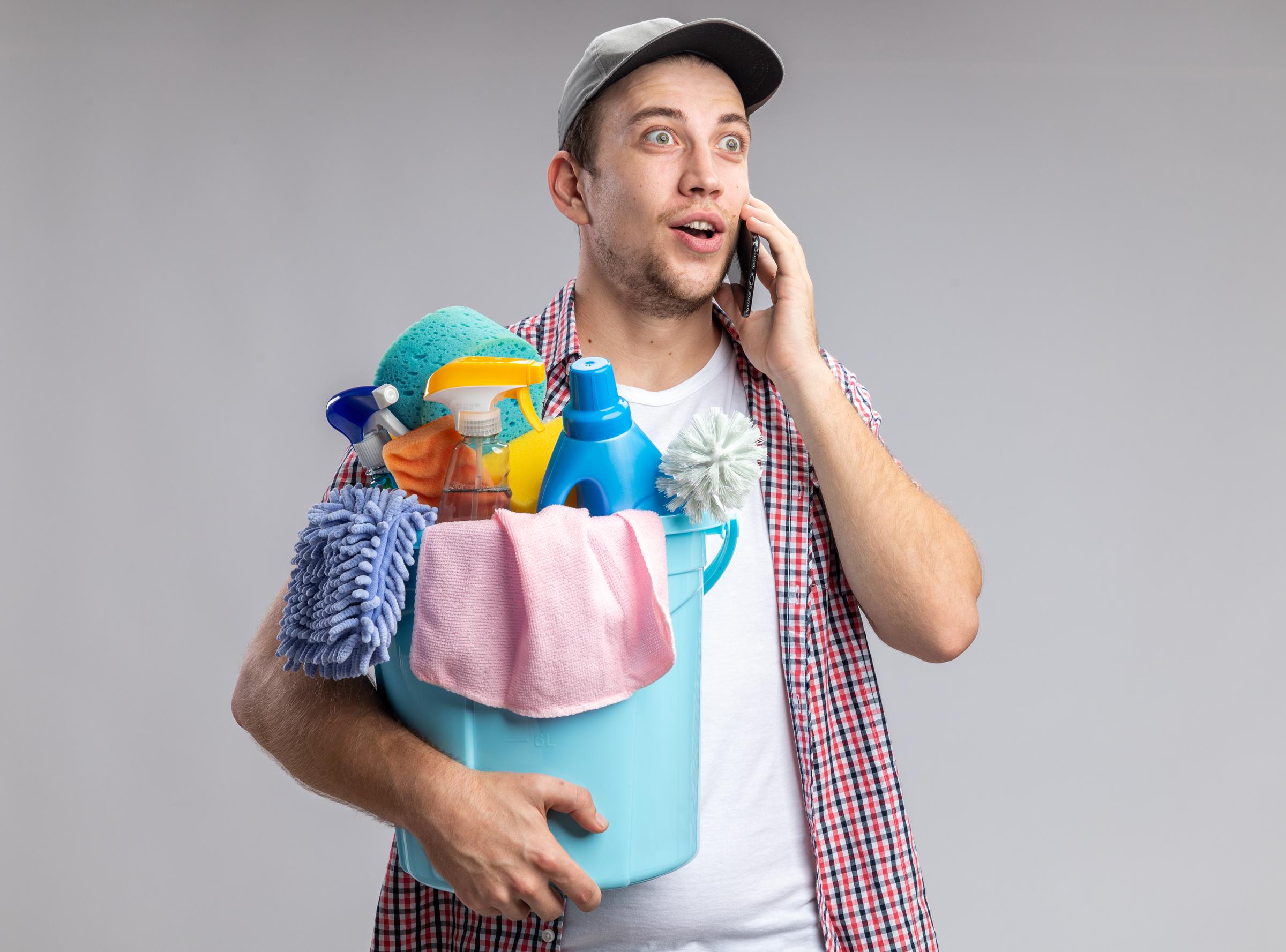 A male cleaner on a phone call | Source: Freepik