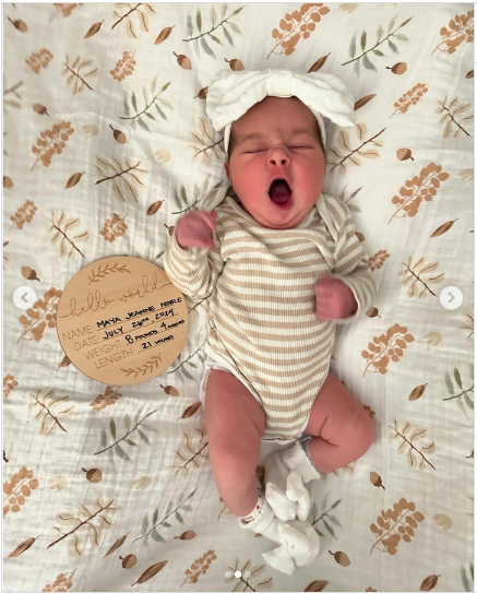 A photo of Kirk Camerons first grandchild, Maya Jeanne Noble Bower wearing a brown and white stripped onesie posted on July 29, 2024 | Source: Instagram/ahnacameronbower