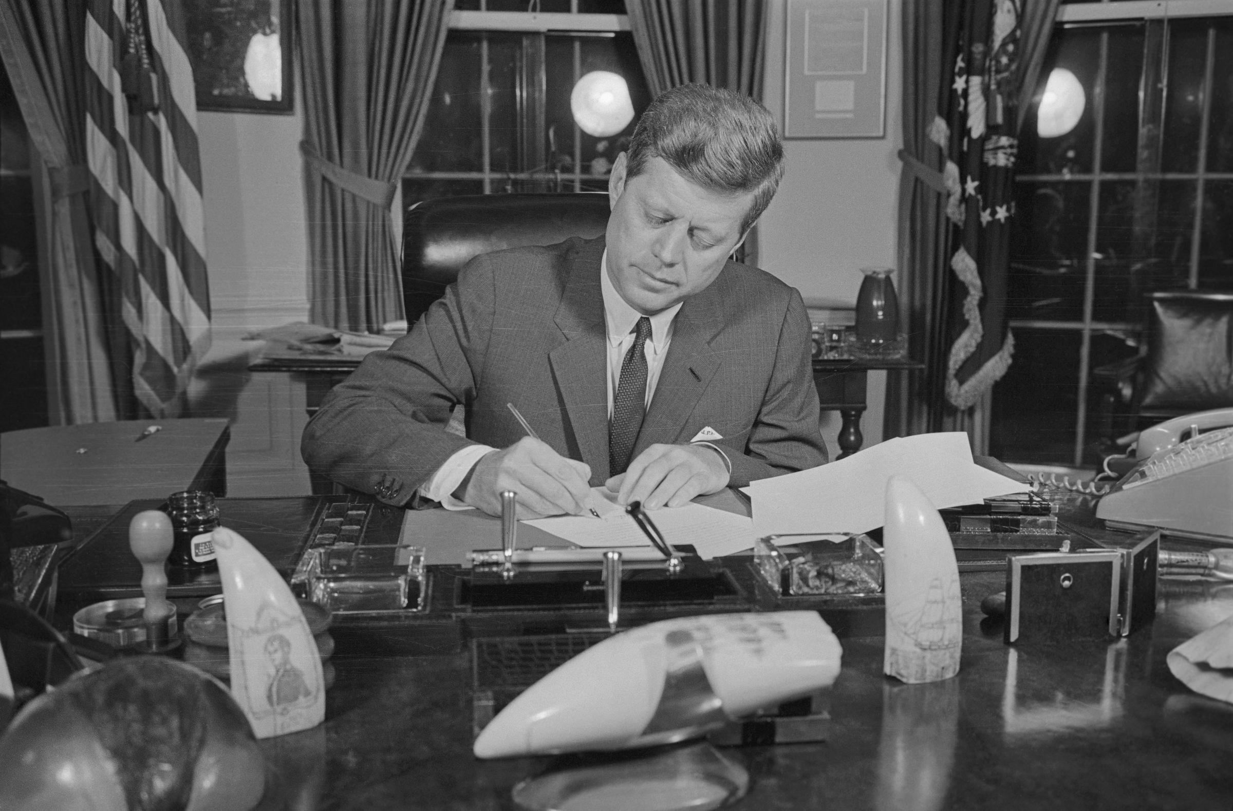 Former president John F. Kennedy signing the Blockade Order in his office in 1962. | Source: Getty Images