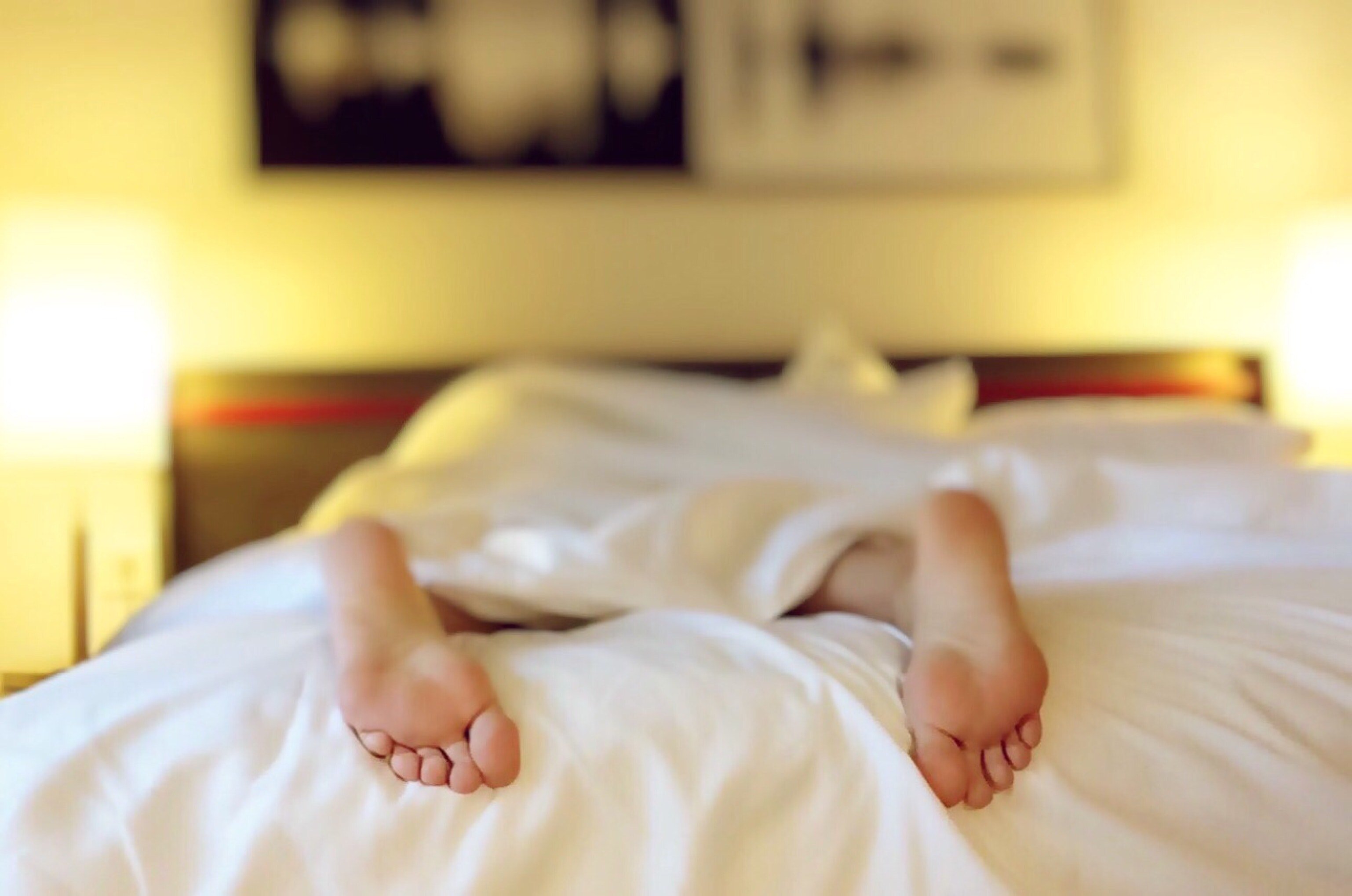 Pies de una persona dormida en una cama. | Foto: Pexels