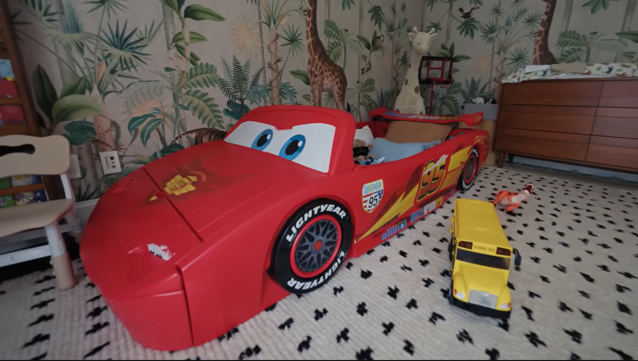 Leo's room features a bold red Lightning McQueen racing car bed parked right on a patterned rug. | Source: YouTube/@Archdigest