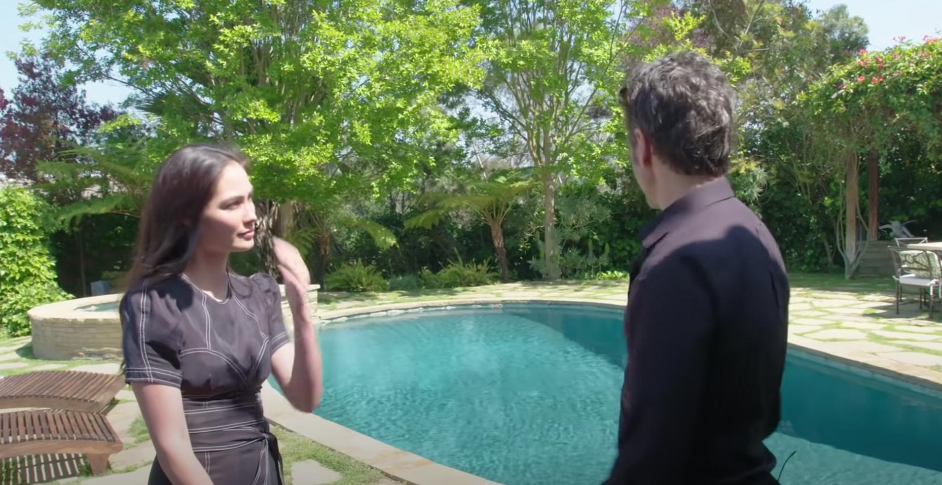 John Stamos and Caitlin McHugh pictured outdoors near the pool in their former home in Los Angeles | Source: YouTube@ArchitecturalDigest