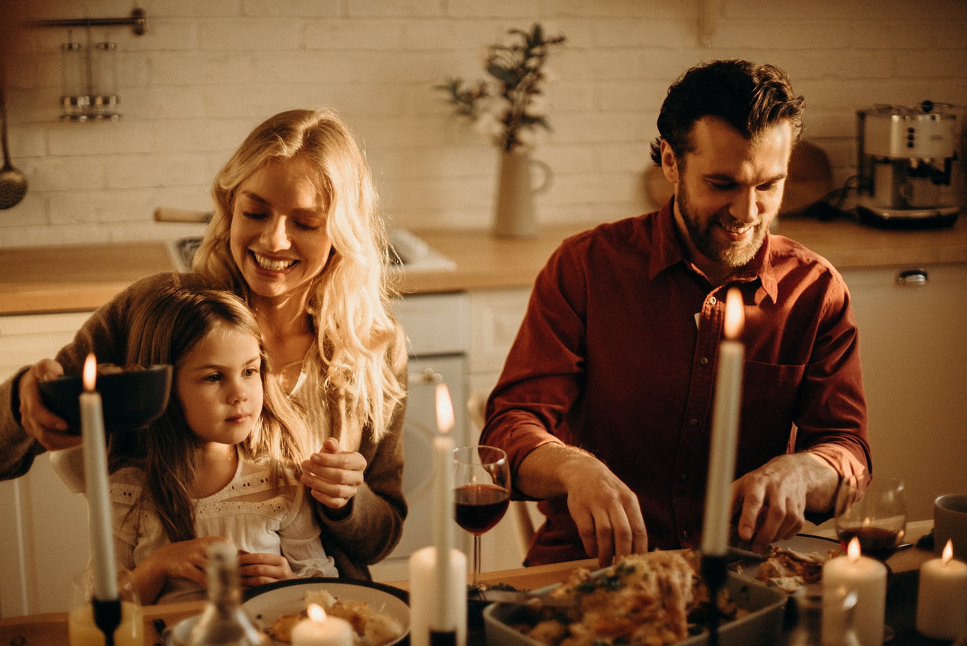 A couple and their daughter pictured at the dinner table | Source: Pexels