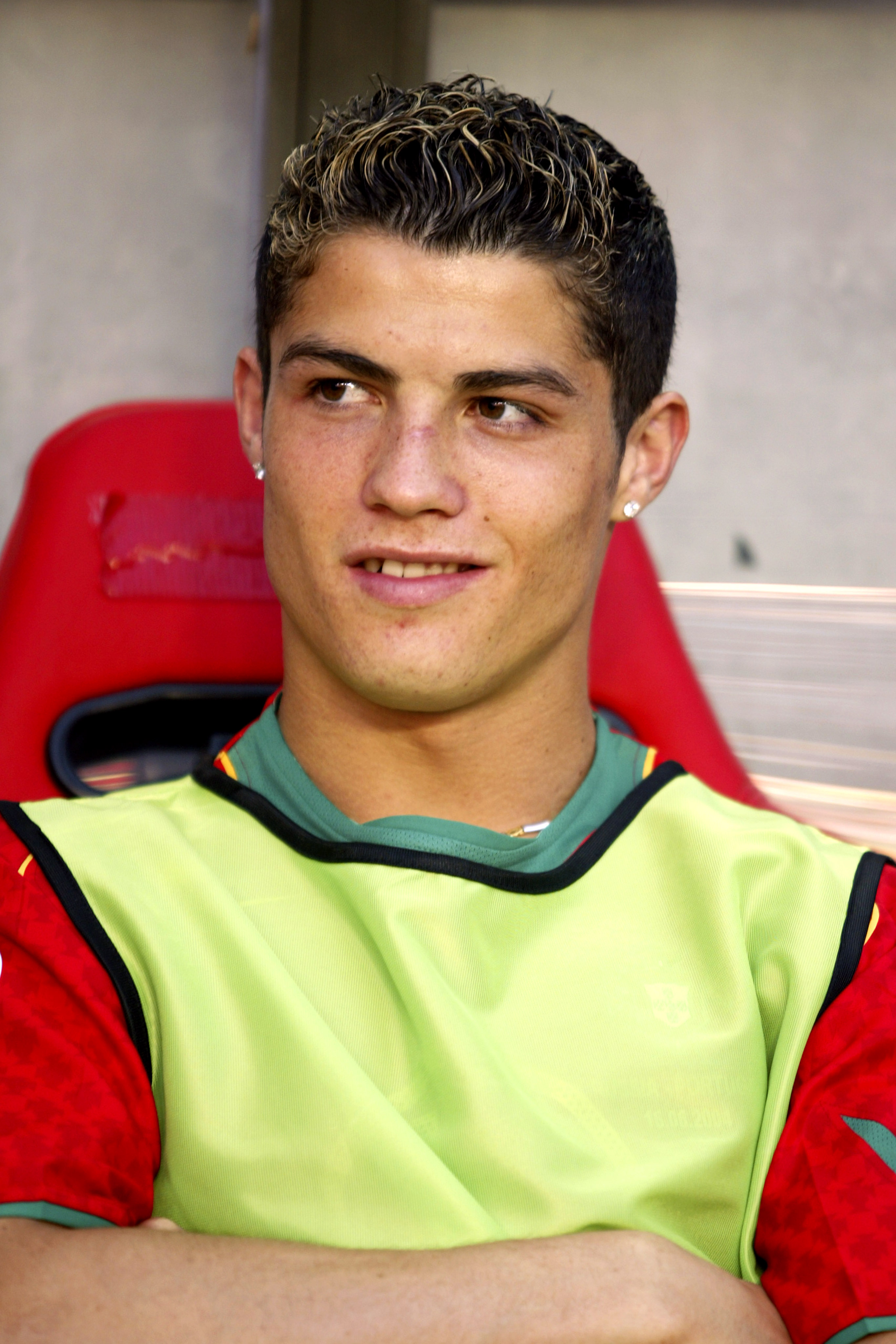 Cristiano Ronaldo watched from the bench during Portugal's UEFA Euro 2004 Group A match against Russia on June 16. Photographed during the tournament that helped introduce him to a global audience, the young forward's natural complexion, softer facial structure, and unaltered smile reflected the early stages of a career that would later transform him into one of the sport's biggest stars.