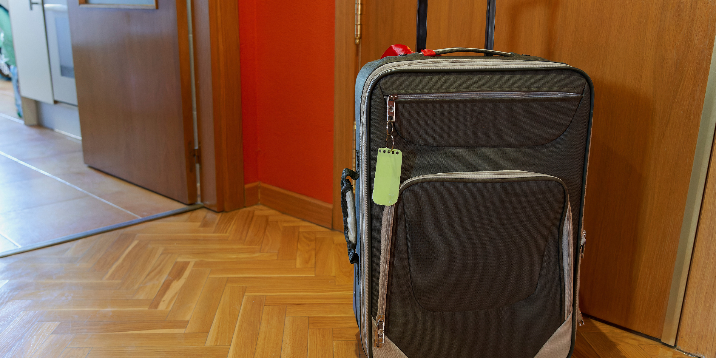 A suitcase placed outside an apartment front door | Source: Shutterstock