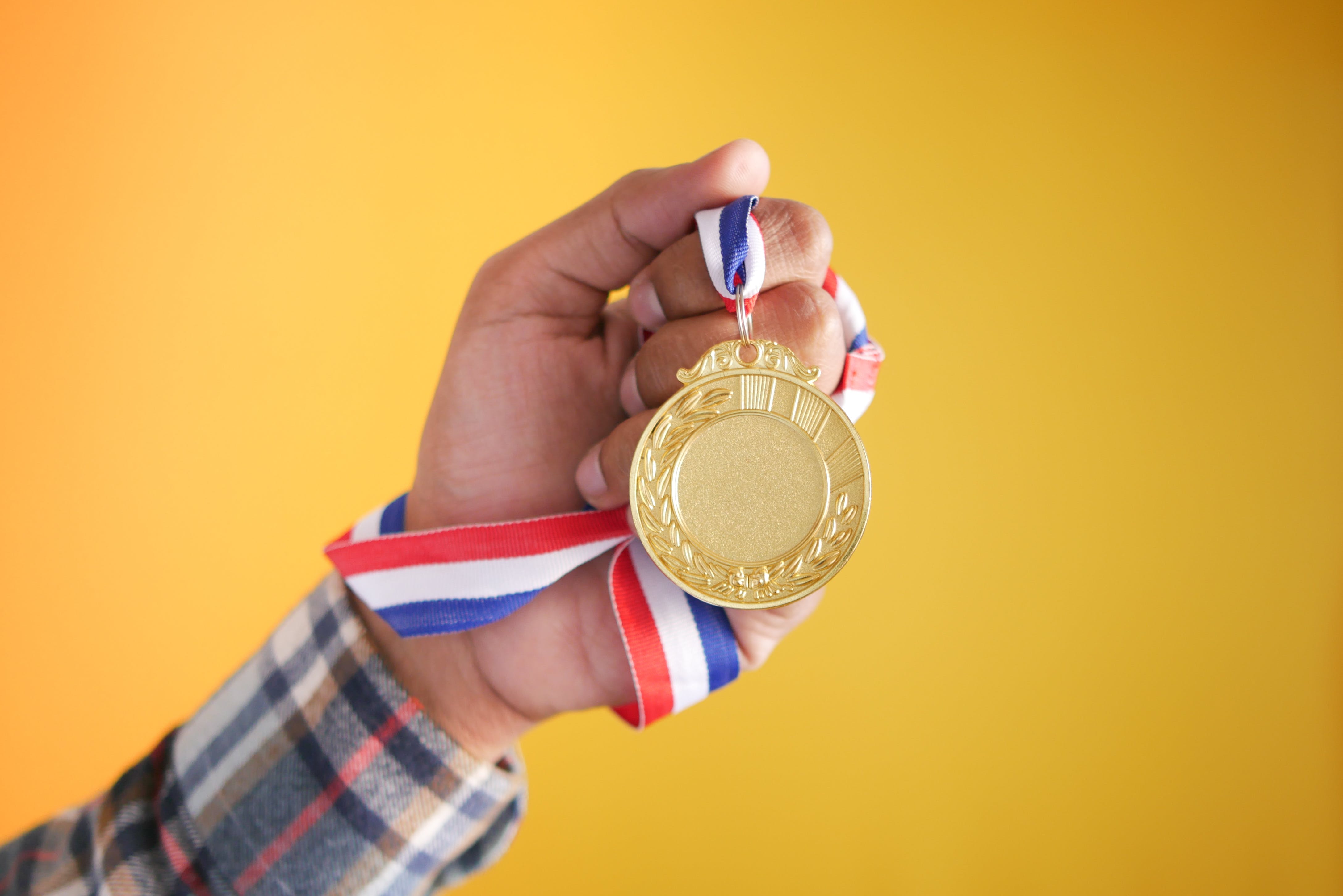 A person holding a medal. | Source: Pexels