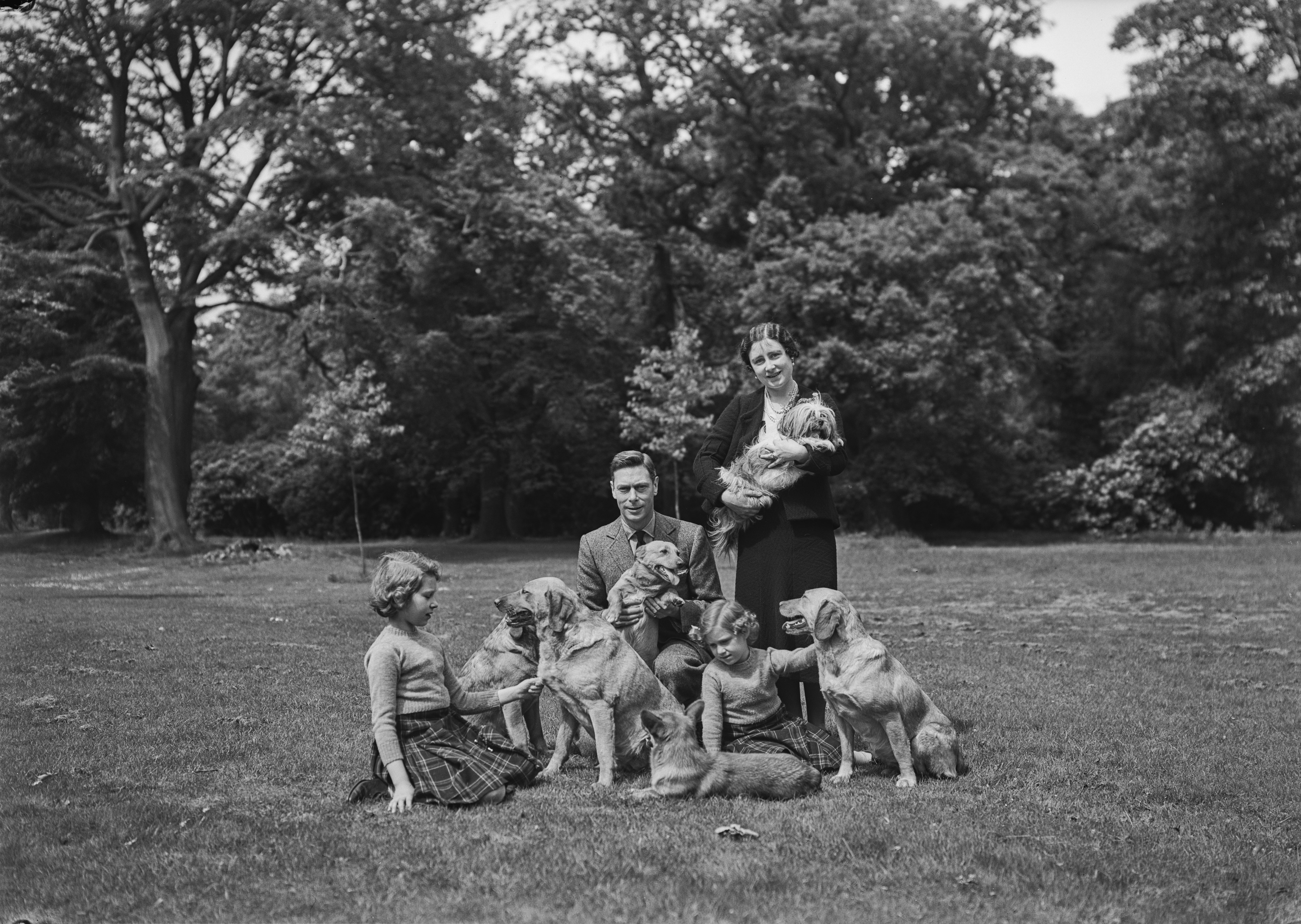 Princesses Margaret and Elizabeth II with their mother, Queen Elizabeth The Queen Mother and their father King George VI with their dogs, including Pembroke Welsh Corgi dogs, Dookie and Jane, and Tibetan Lion Choo-Choo, at the Royal Lodge in June 1936 in Windsor, United Kingdom | Source: Getty Images