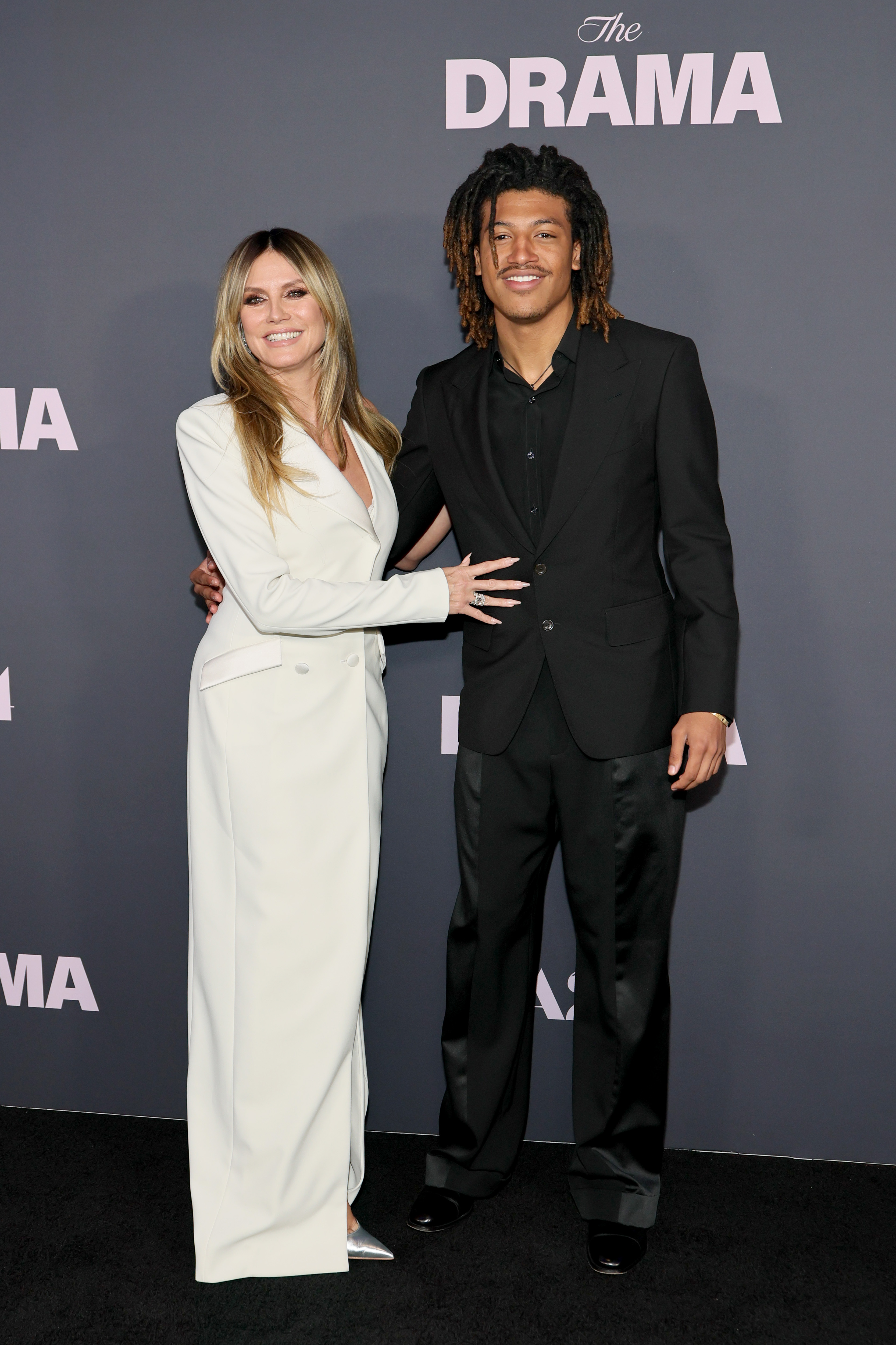 In New York City, at the premiere of "The Drama," Henry Samuel sparks double takes — his look a striking blend of Heidi Klum’s elegance and Seal’s edge.
