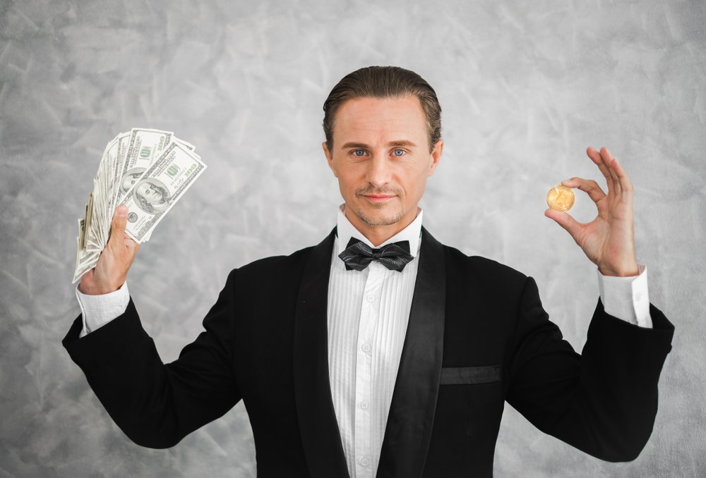 A millionaire holding bitcoin and dollar money. | Photo: Shutterstock