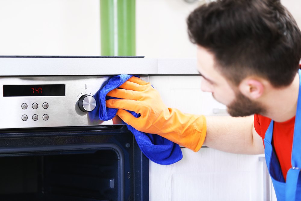 Persona limpiando el horno de la cocina-Imagen tomada de Shutterstock Persona limpiando el horno de la cocina-Imagen tomada de Shutterstock