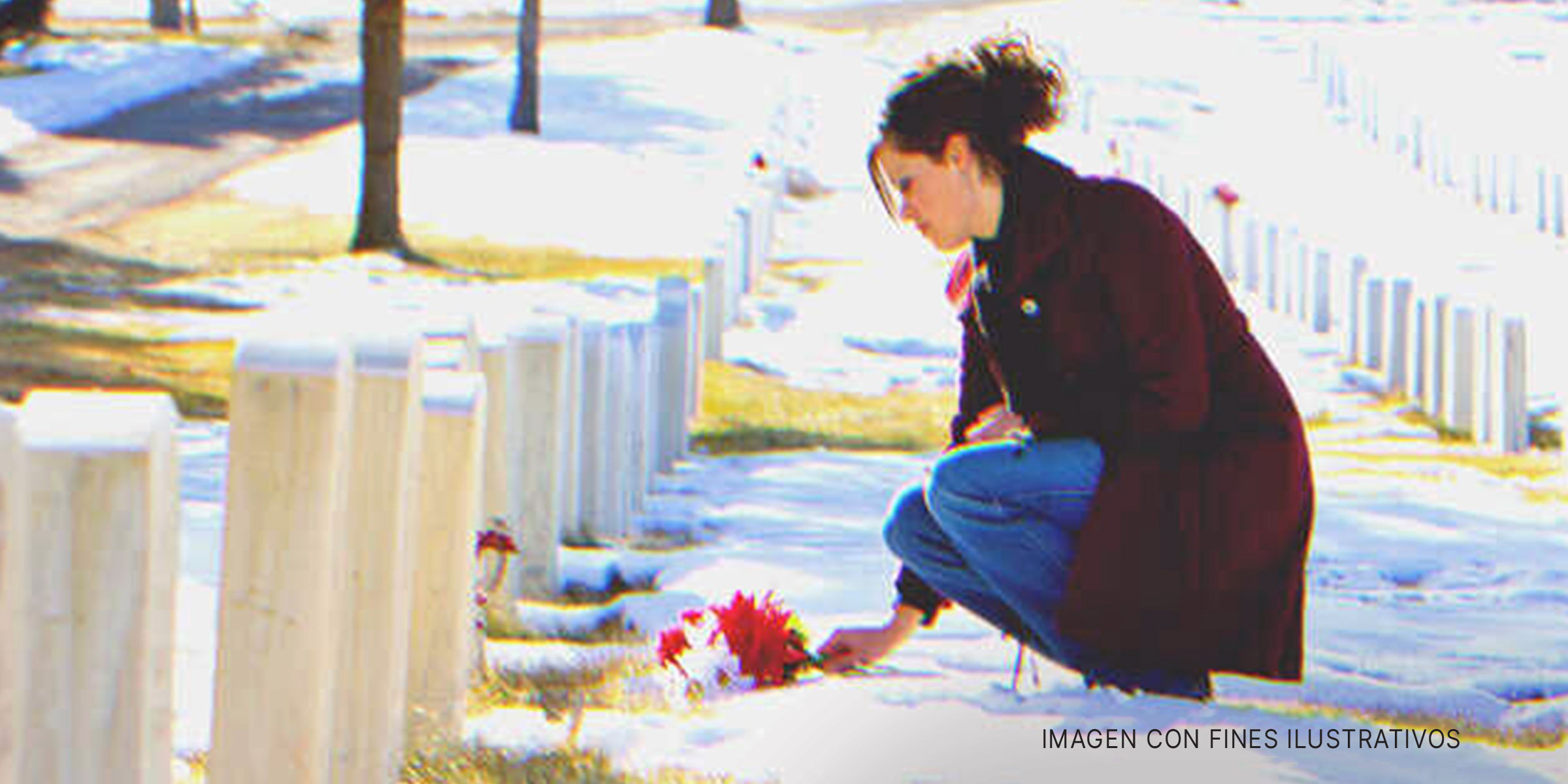 Mujer joven deja flores sobre una tumba. | Foto: Getty Images