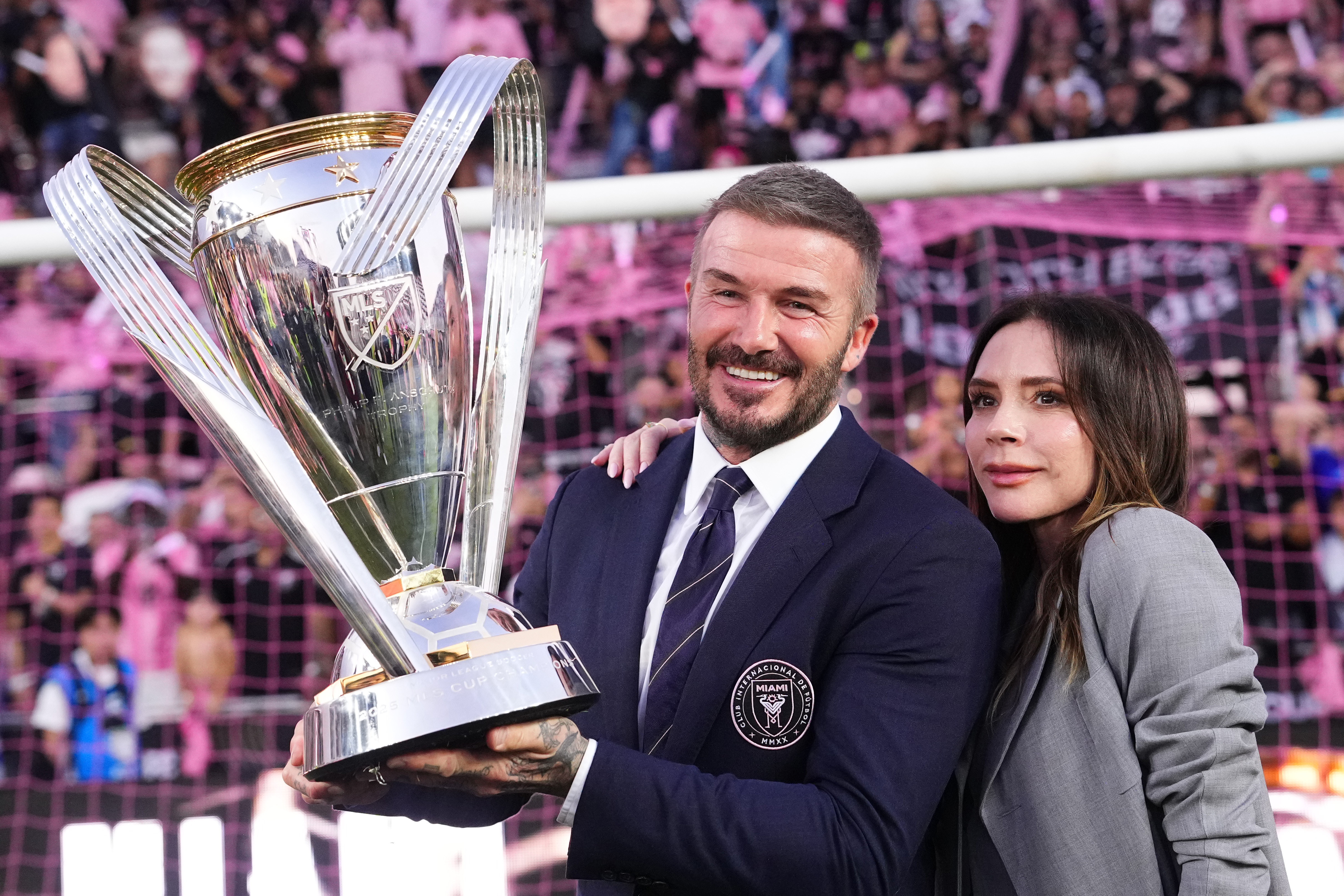 Sir David Beckham, co-owner of Inter Miami CF, and Victoria Beckham pose with the trophy after winning the Championship following the Audi 2025 MLS Cup Final match between Inter Miami CF and Vancouver Whitecaps FC at Chase Stadium on December 6, 2025 in Fort Lauderdale, Florida. | Source: Getty Images