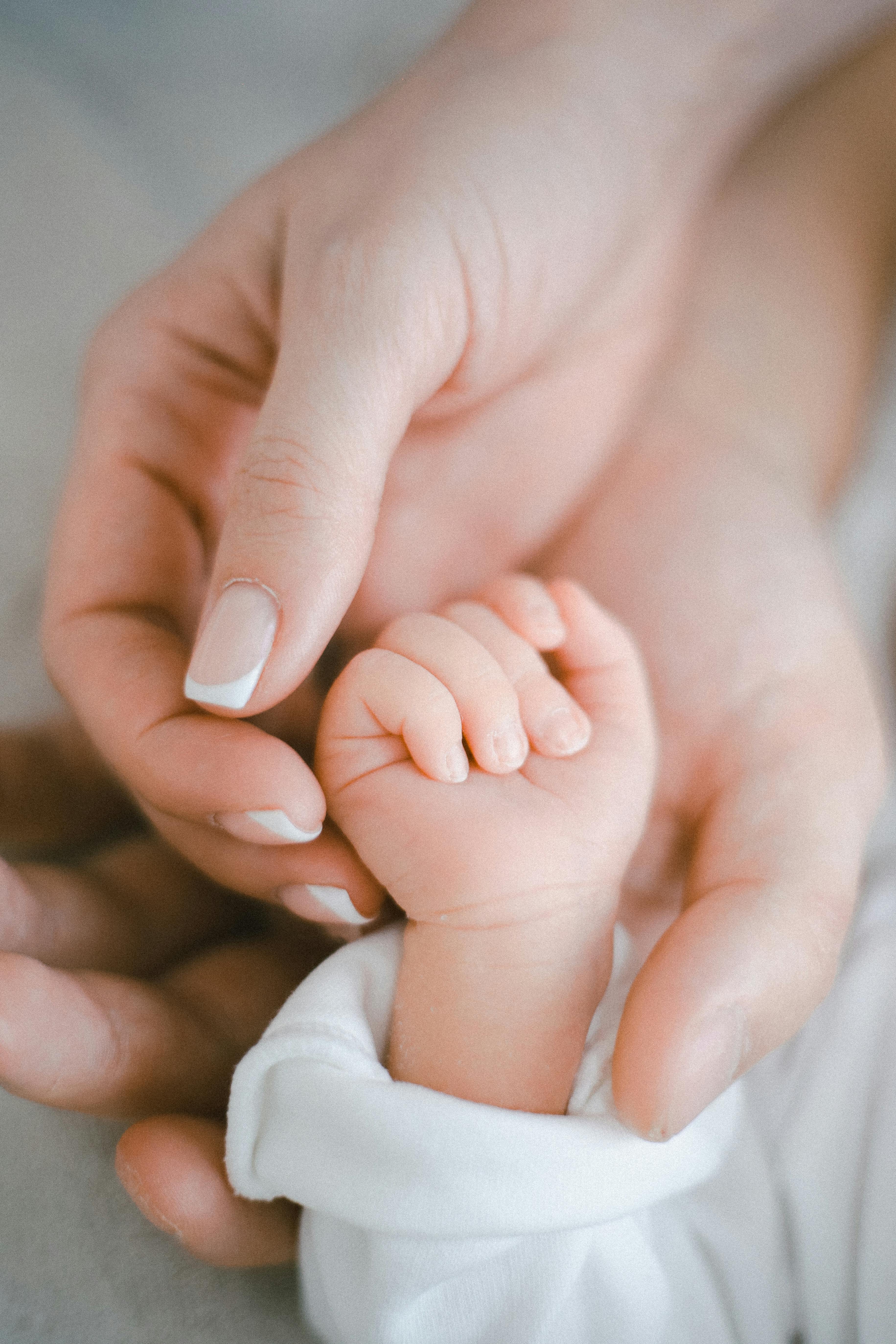 Parents' hands holding their little one's | Source: Pexels