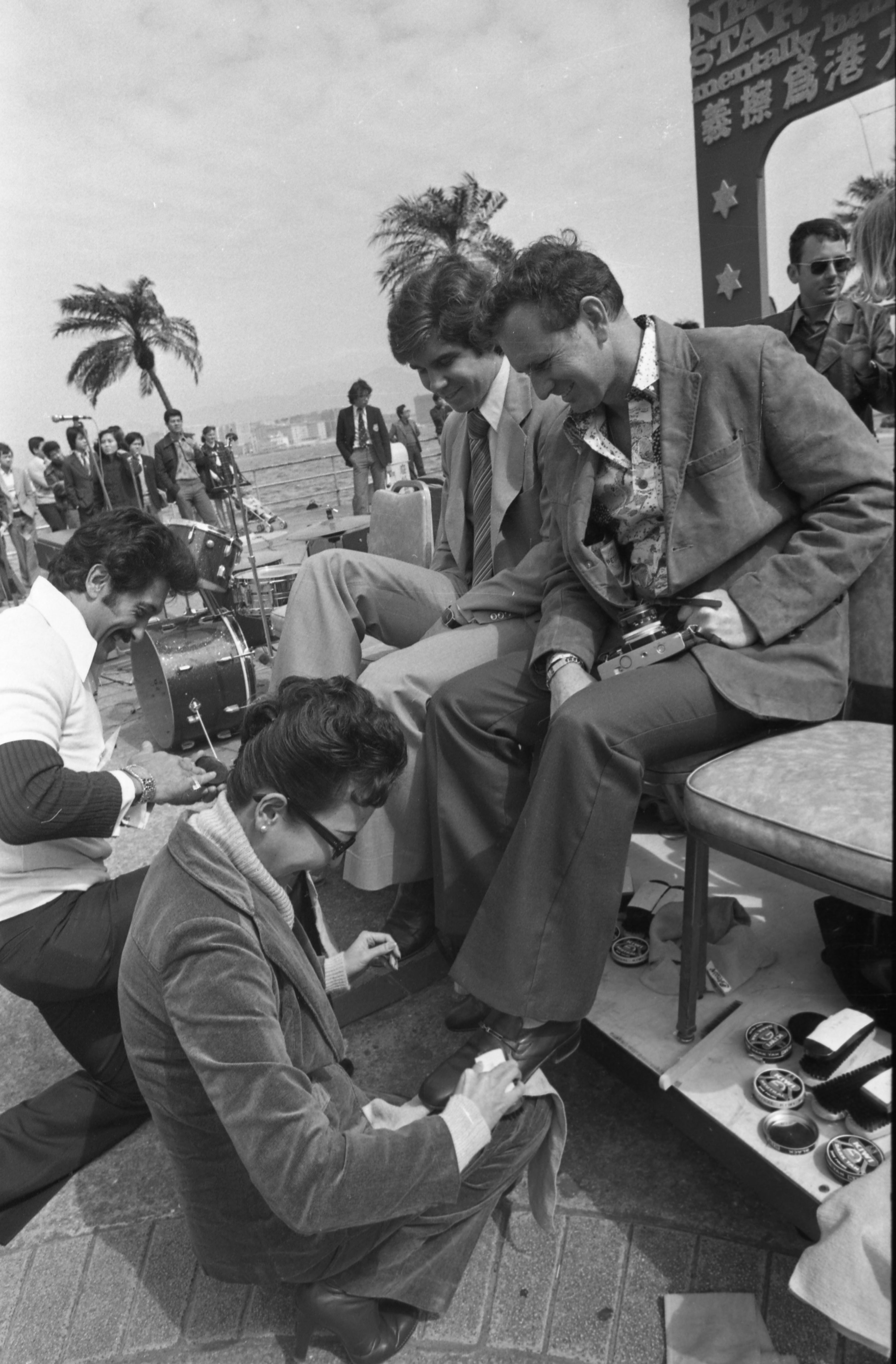 Nelson Sardelli (left) and Kim Hall shining the shoes of James Grove and Ian Duncan during the second annual "Starshine" event at Edinburgh Place to raise funds for mentally handicapped children in 1978. | Source: Getty Images