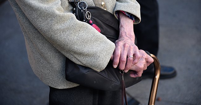 An old woman leaning on her cane for support. | Photo: Getty Images