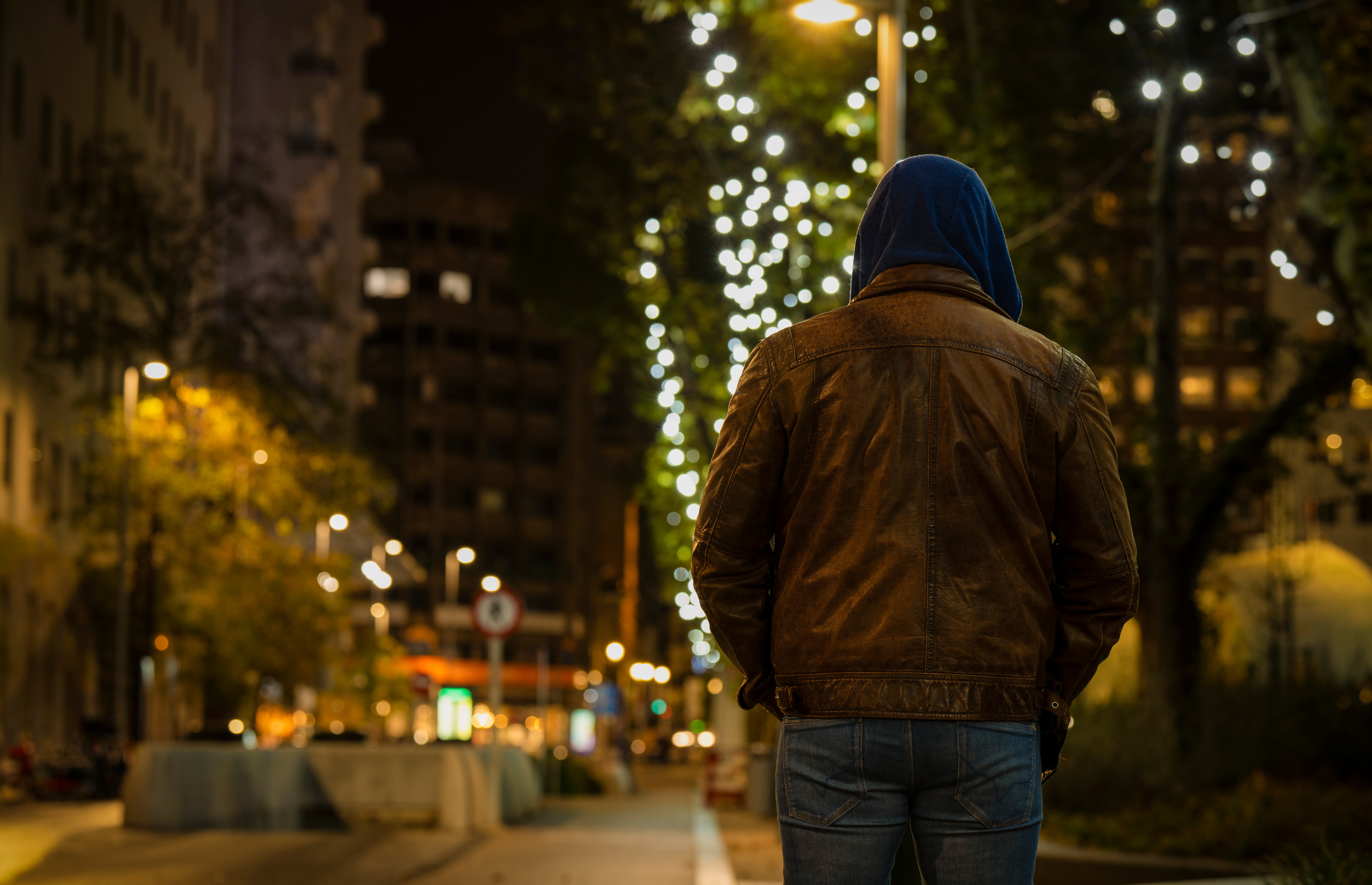 Rear view of adult man on street at night. | Source: Shutterstock