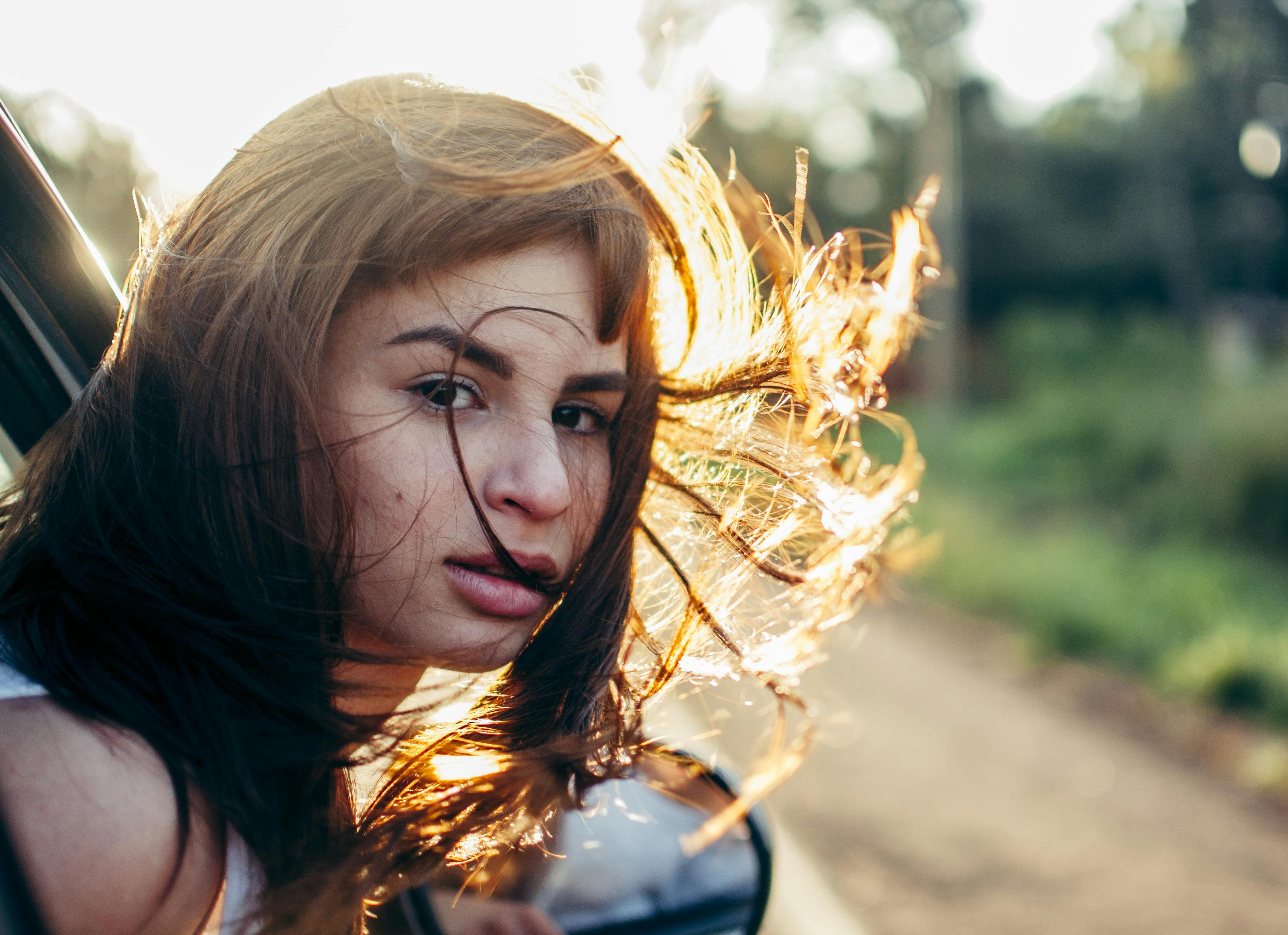 A young girl with her head outside a car window while being driven | Source: Pexels