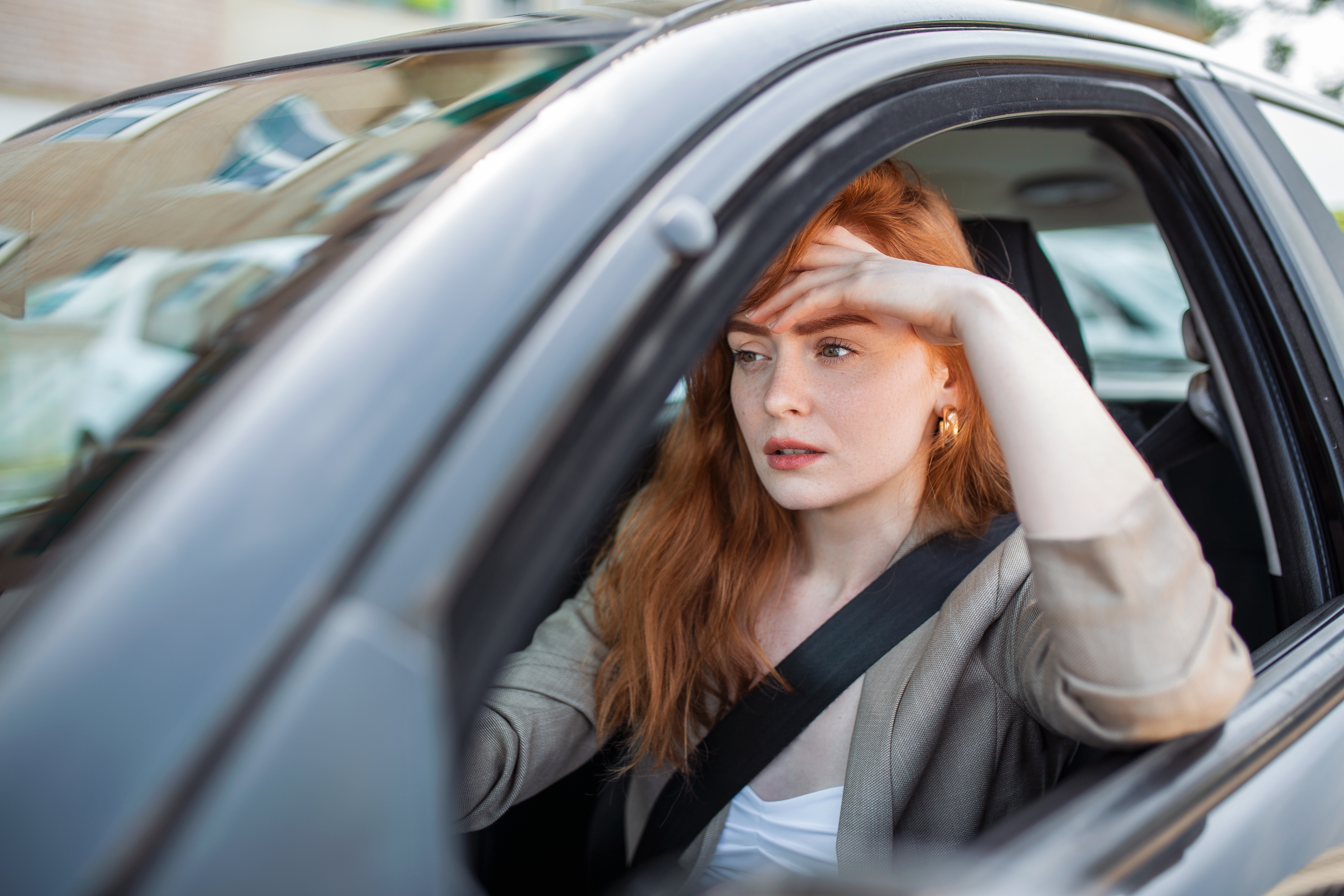 A stressed woman driving a car | Source: Shutterstock