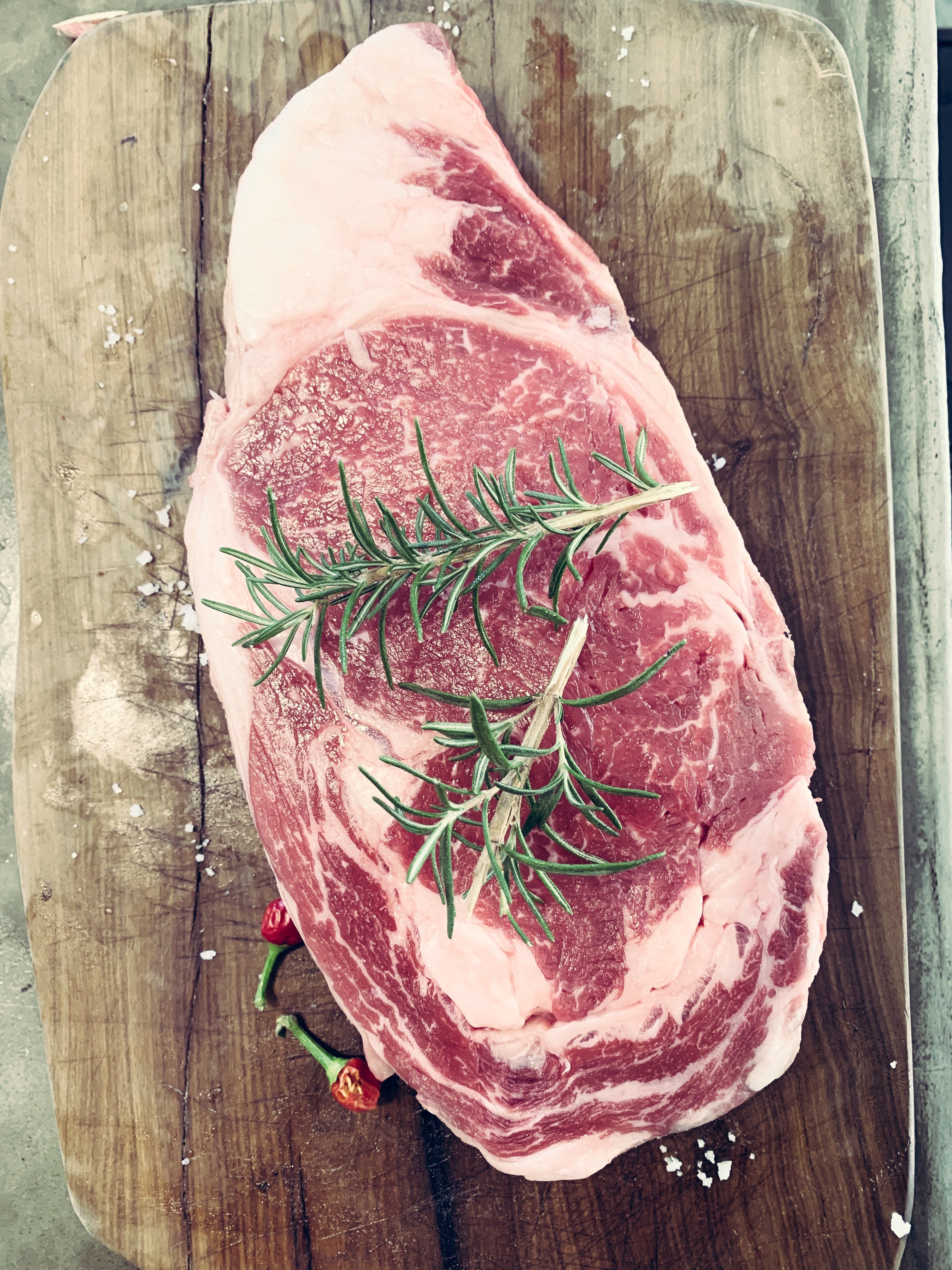 Big meat on a wooden surface with leaves on it | Source: Unsplash/Charlie Solorzano