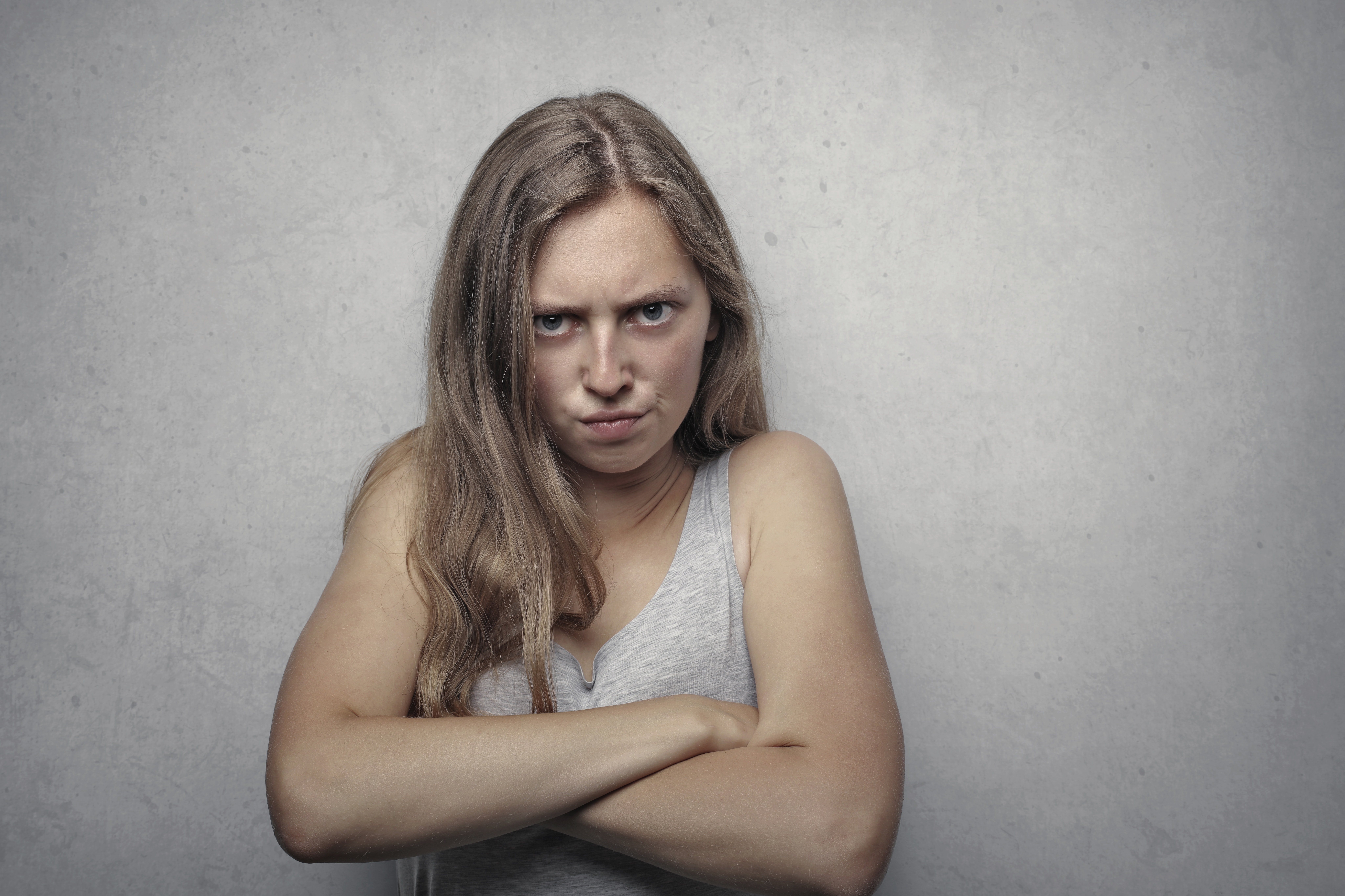 An angry woman with their arms crossed. │Source: Pexels