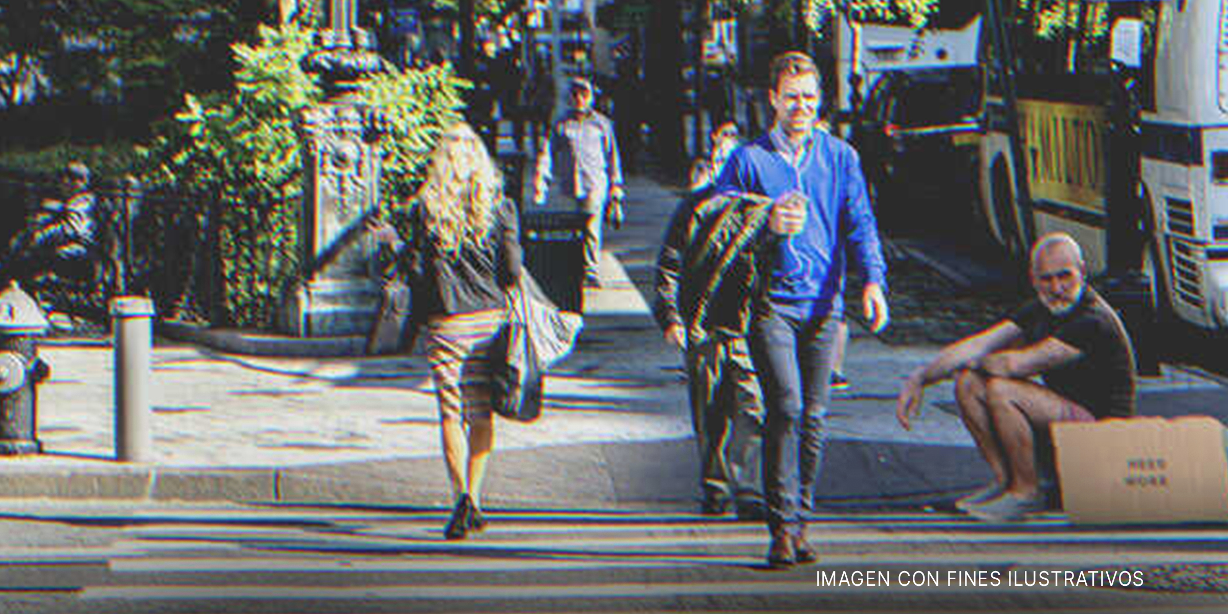 Personas caminando al lado de un hombre con un cartel | Foto: Shutterstock