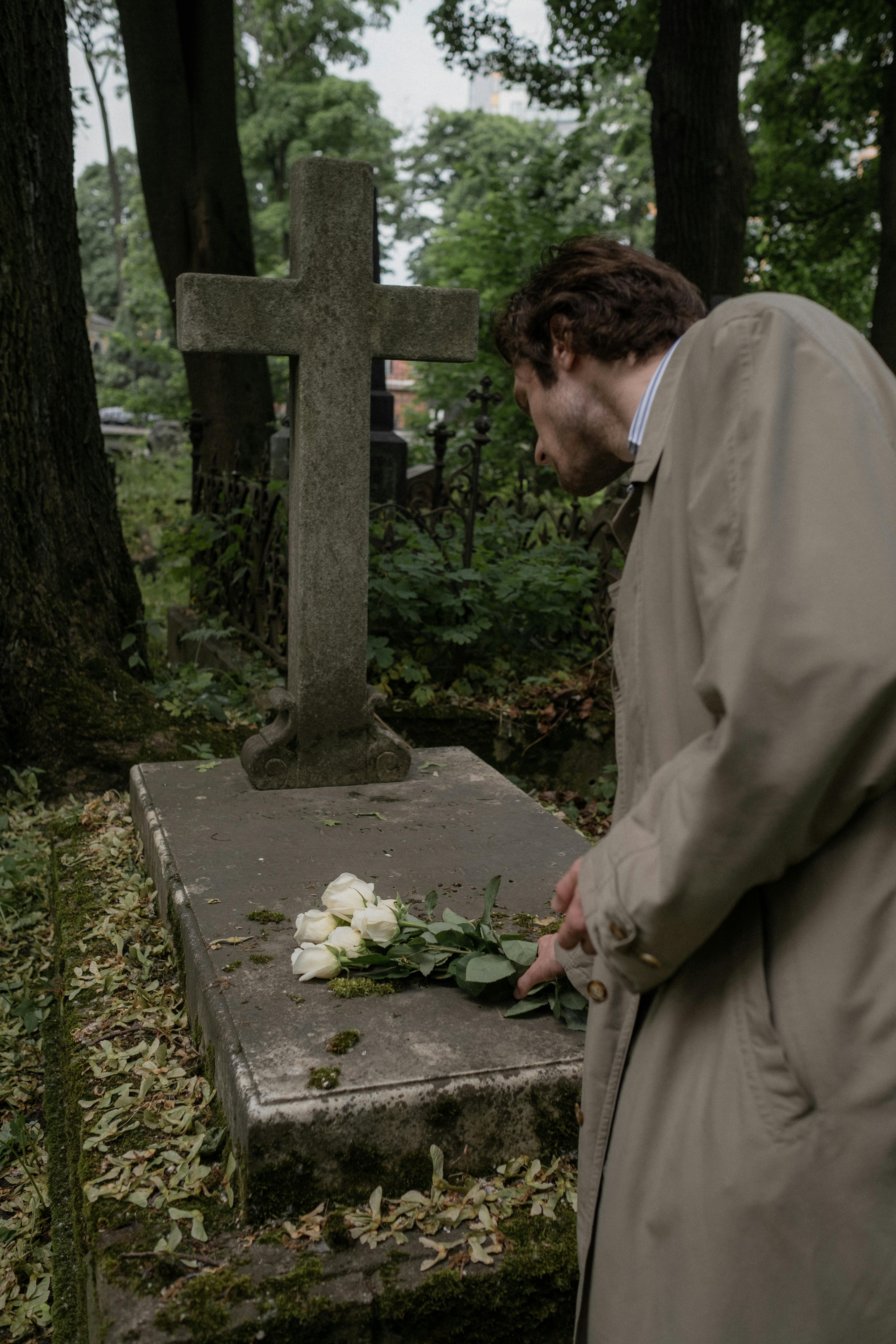 A person placing flowers on a grave | Source: Pexels