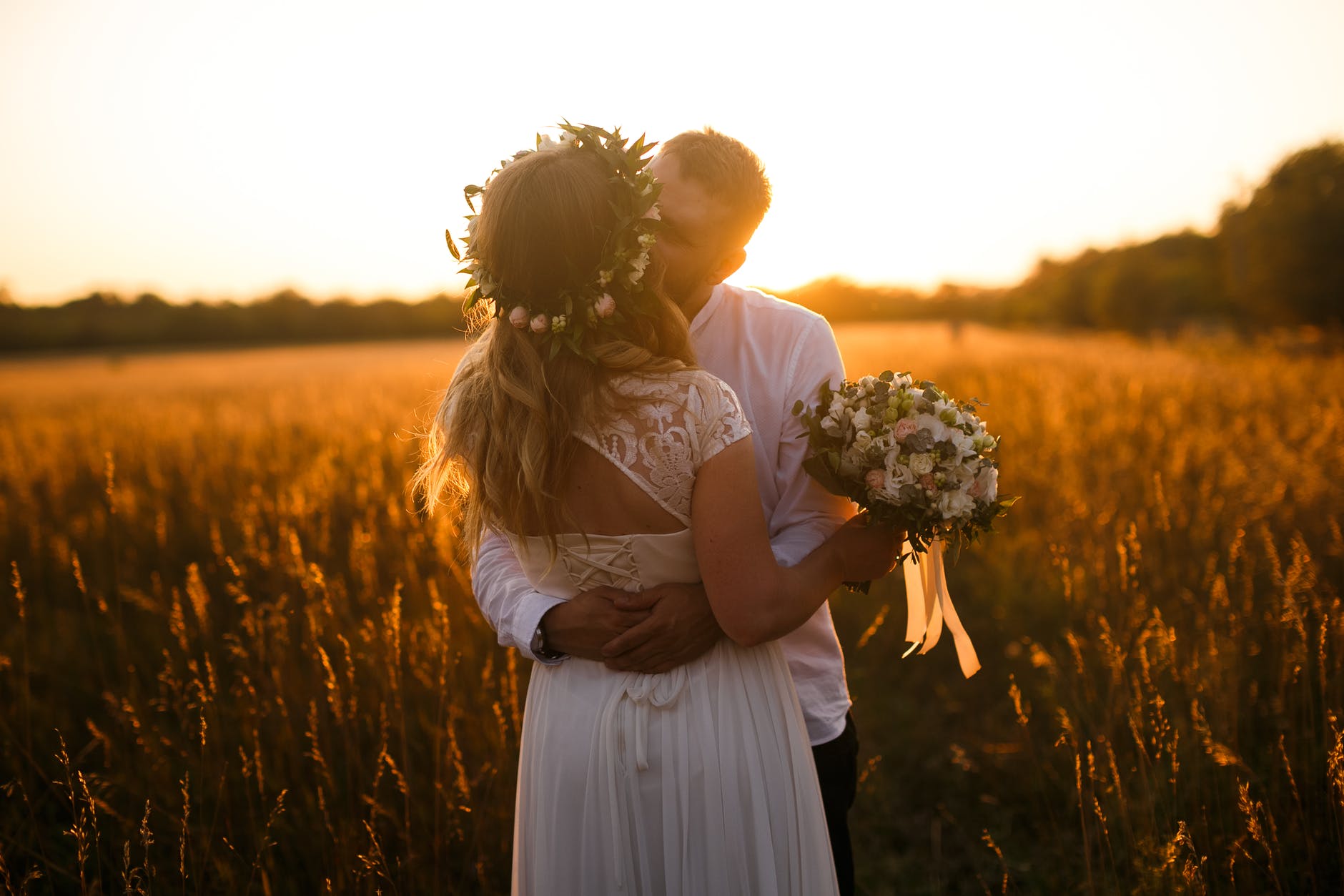 Una pareja de recien casados se da un beso en el campo. | Foto: Pexels