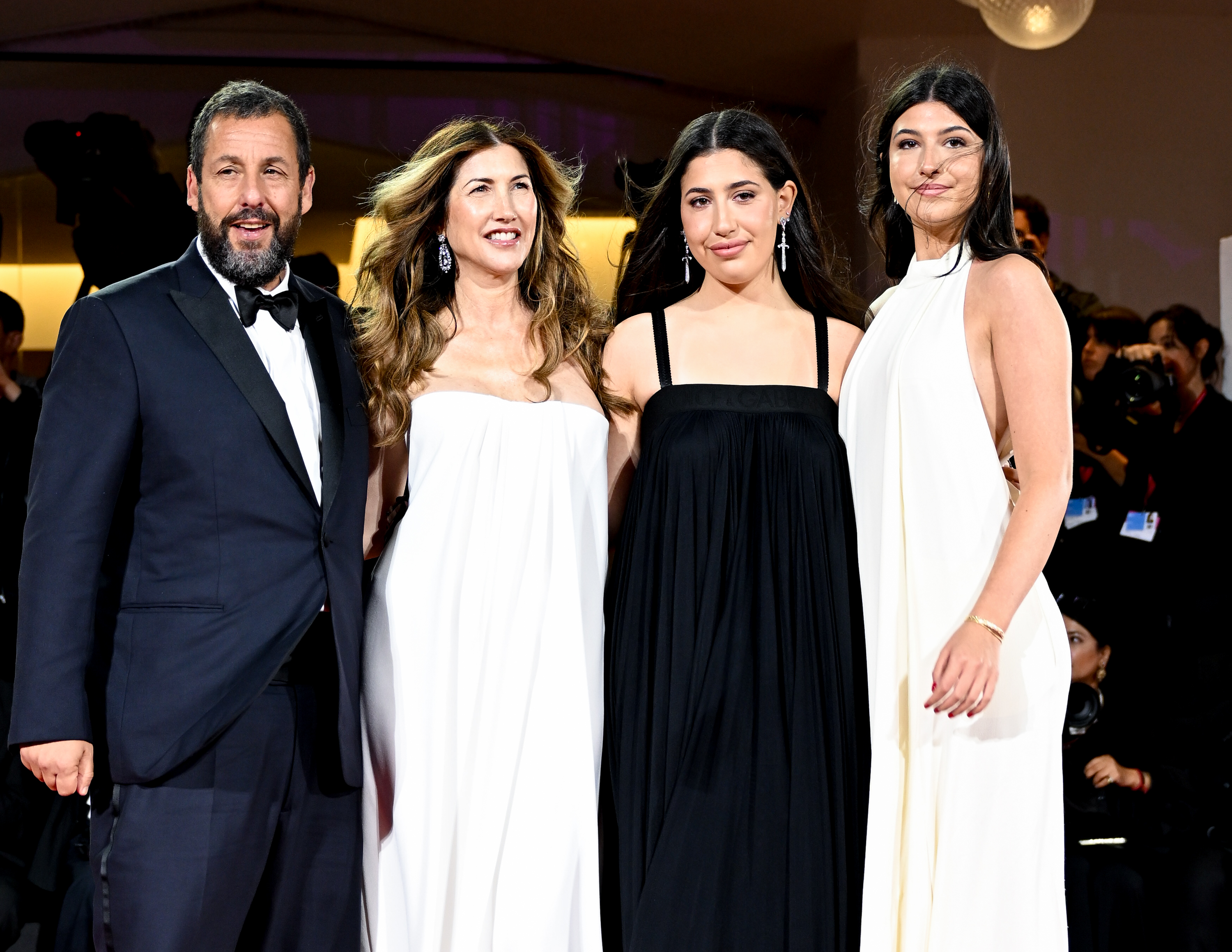 Still at the “Jay Kelly” red carpet during the 82nd Venice International Film Festival, Adam Sandler poses with Jackie, Sunny, and Sadie. The trio of women looks radiant, their long hair catching the wind. Together, they make for a picture-perfect family moment.