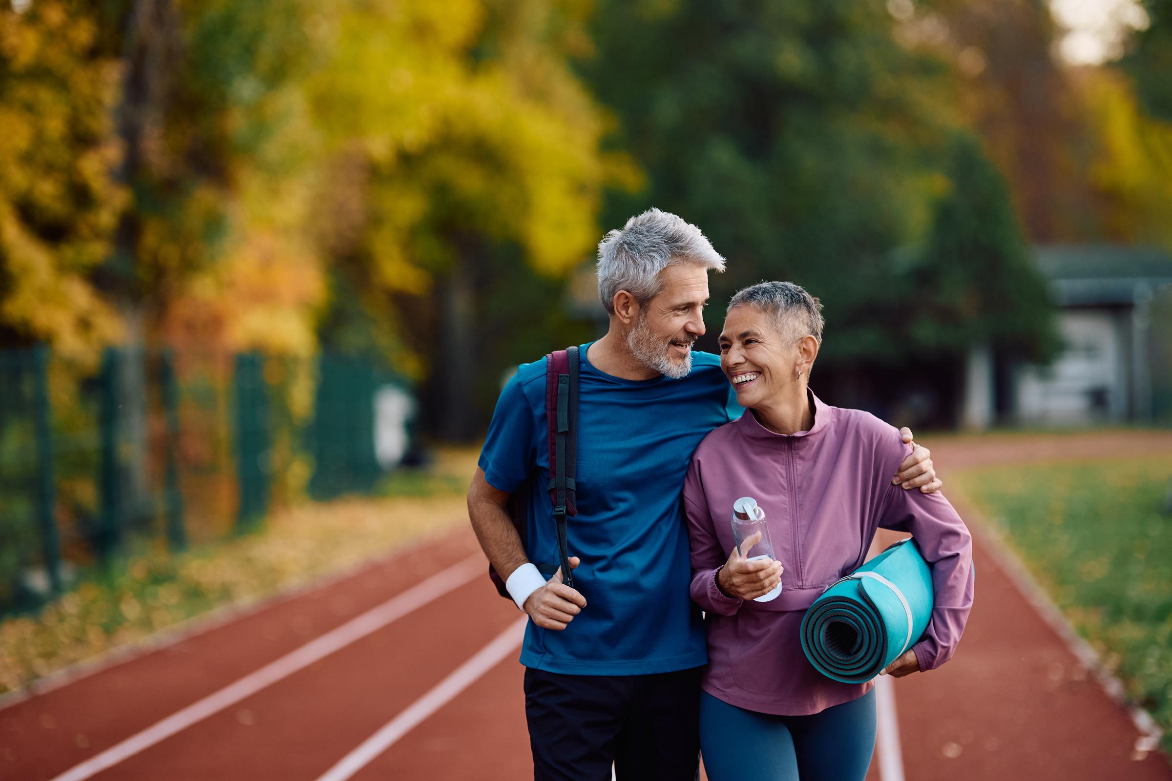 A couple walking on a running track after exercising at a park | Source: Getty Images