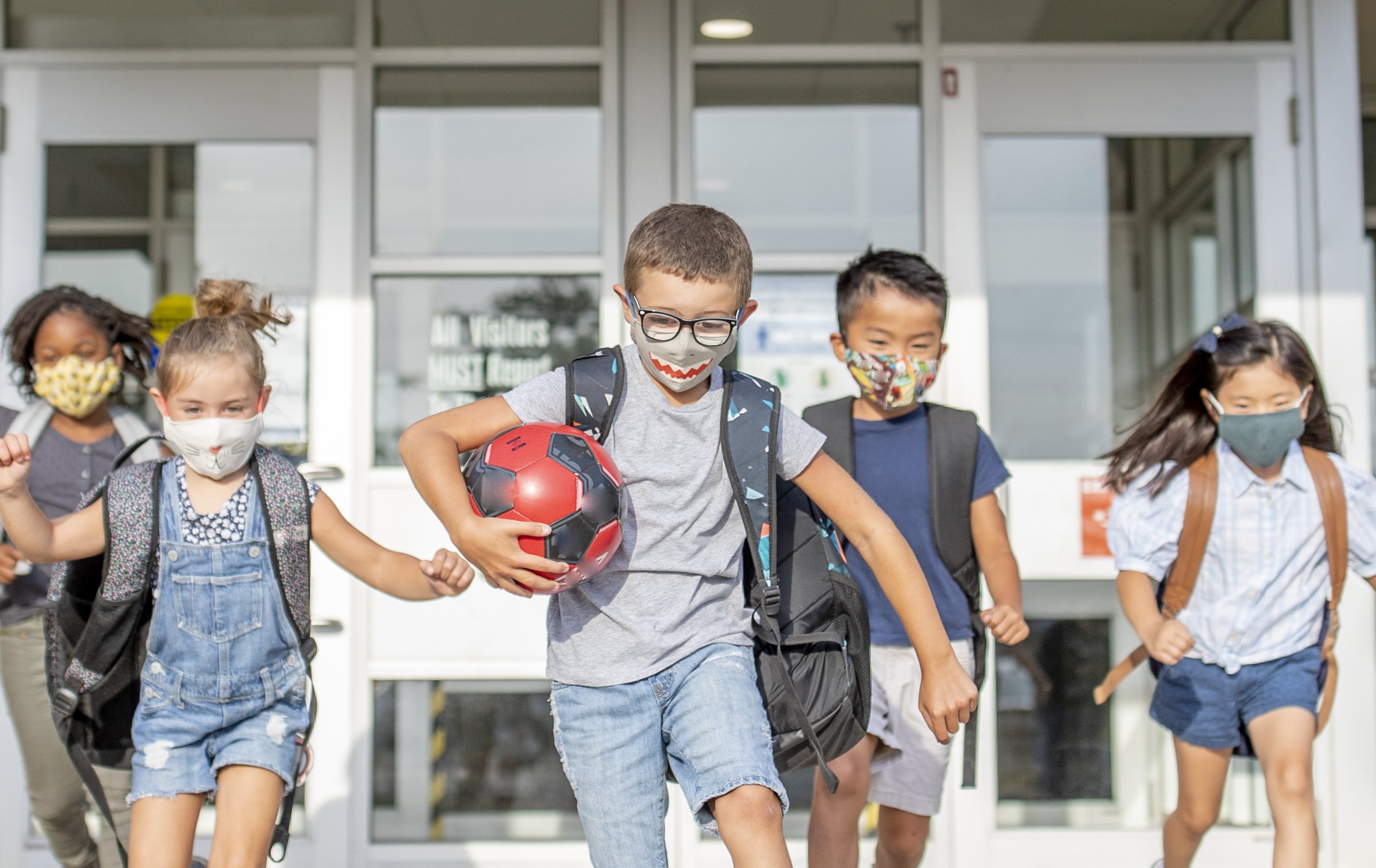 Des enfants dans une cour de recréation avec des masques I photo: Getty Images