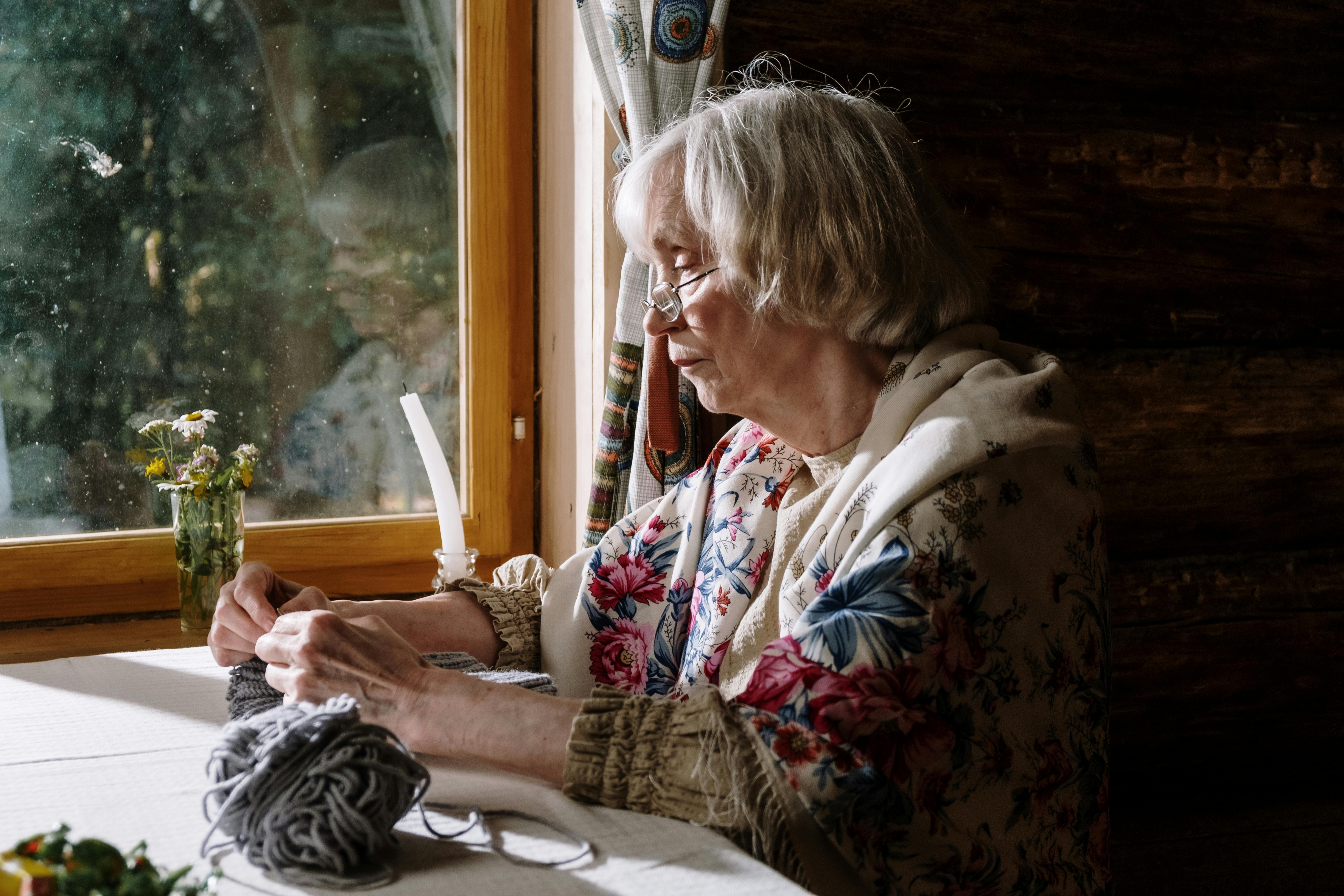 Gran knitting by the window, proud and content | Source: Pexels