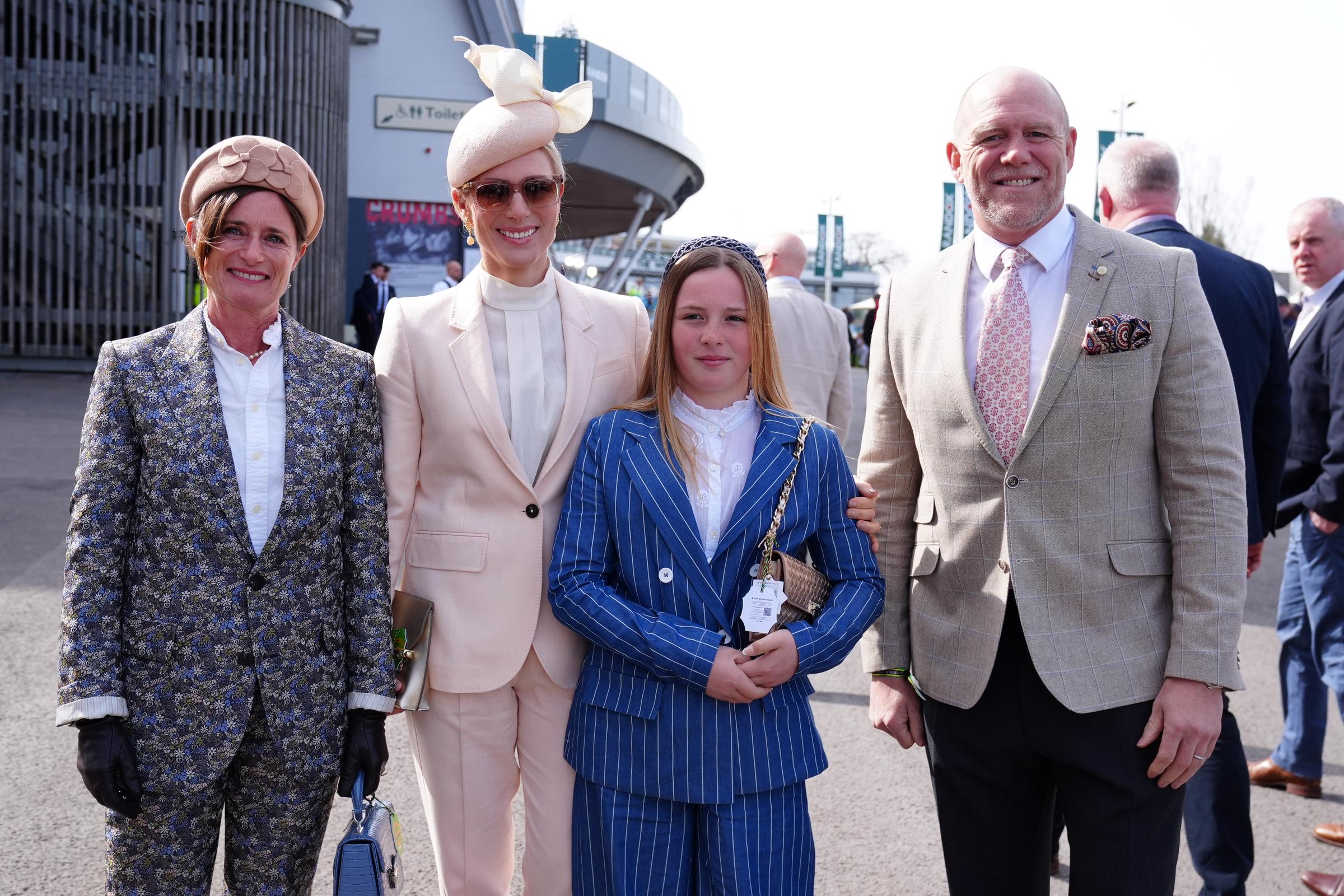 Zara Tindall, Mia Tindall, and Mike Tindall posed for a polished family portrait on Ladies Day at Aintree Racecourse, with 12-year-old Mia commanding attention in a sharp blue pinstripe suit as she stood confidently between her parents, mirroring her mother's refined race-day elegance.