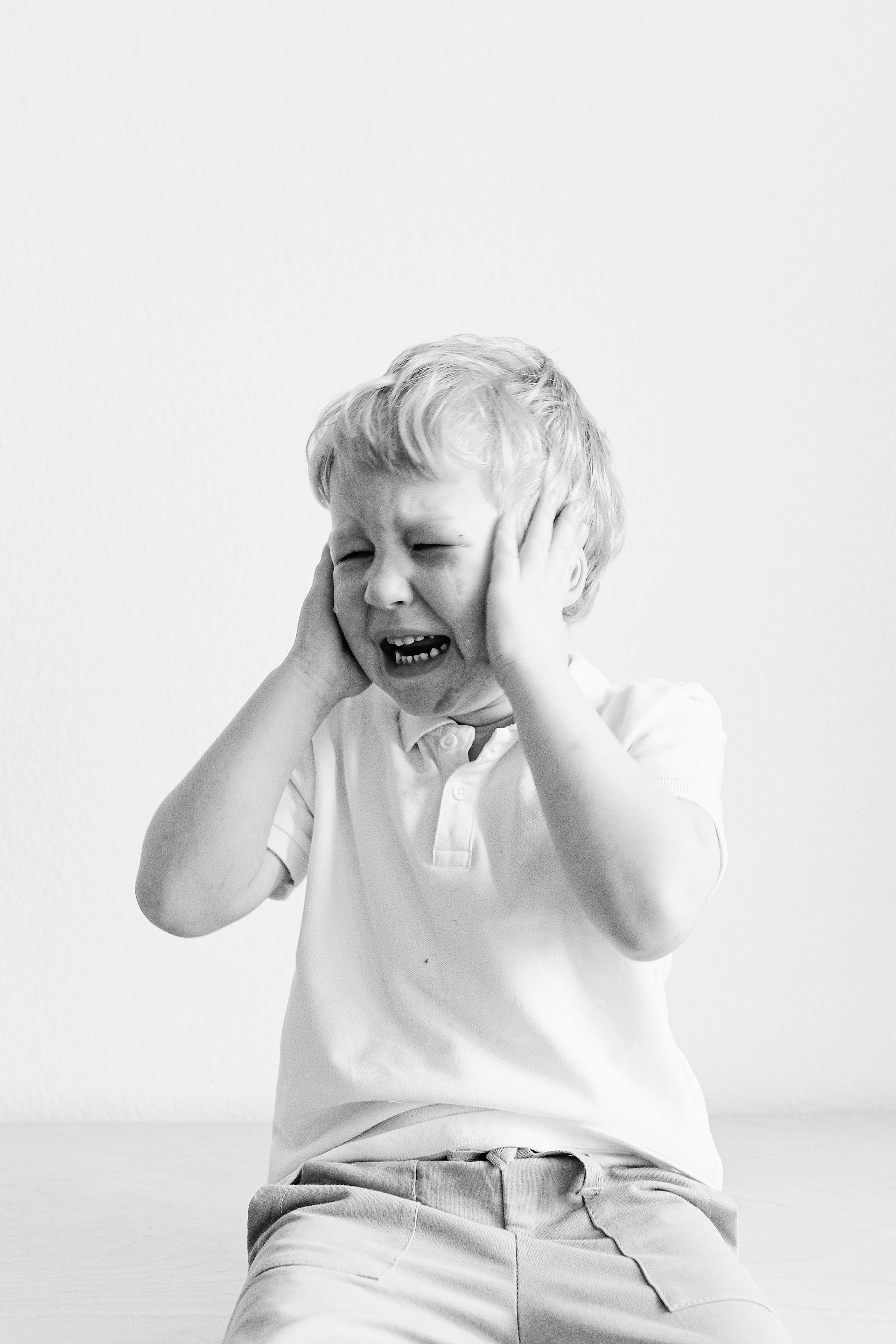 Grayscale of a little boy throwing a tantrum | Source: Pexels