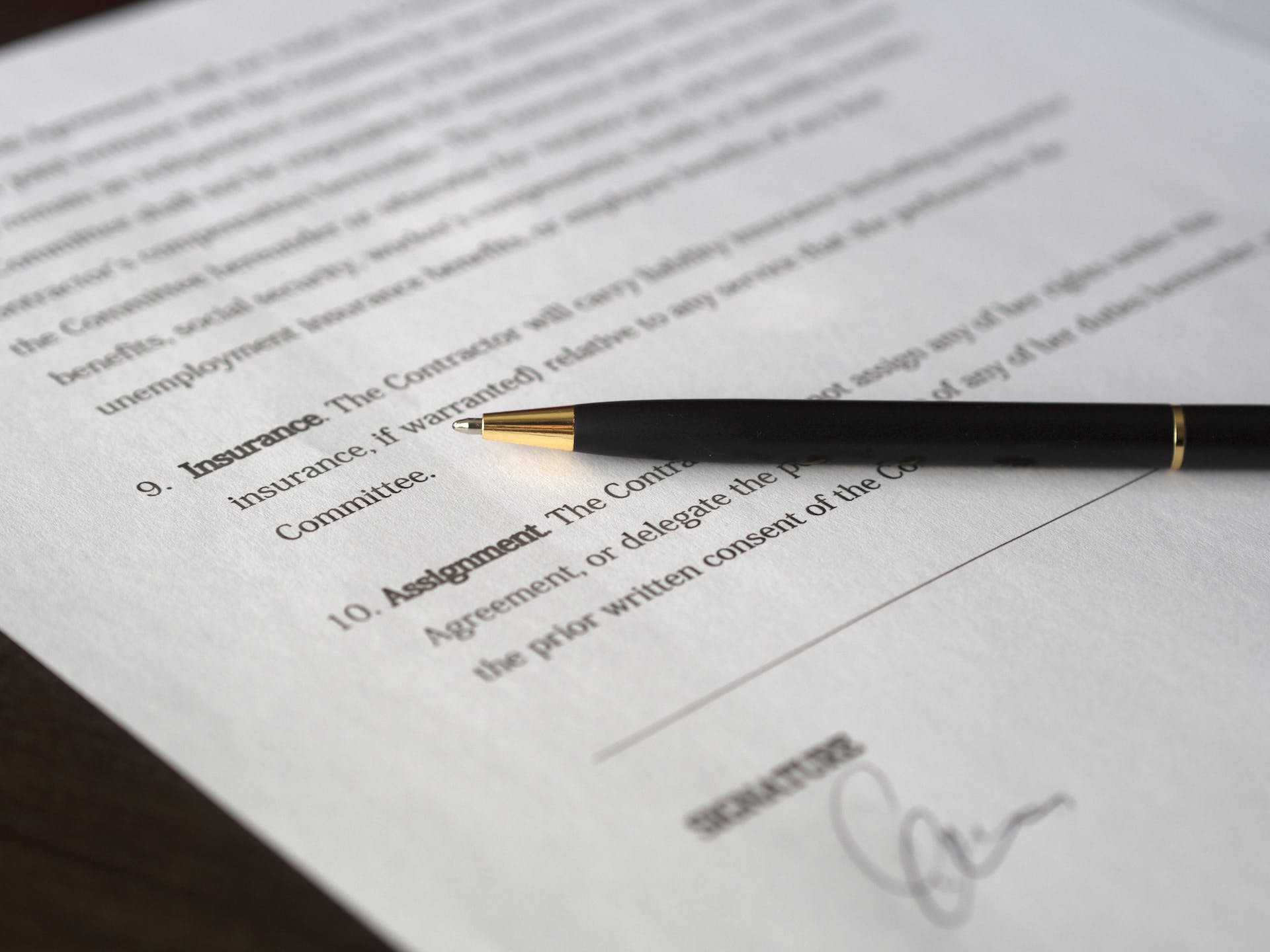 Legal contract with pen on table. | Source: Pexels