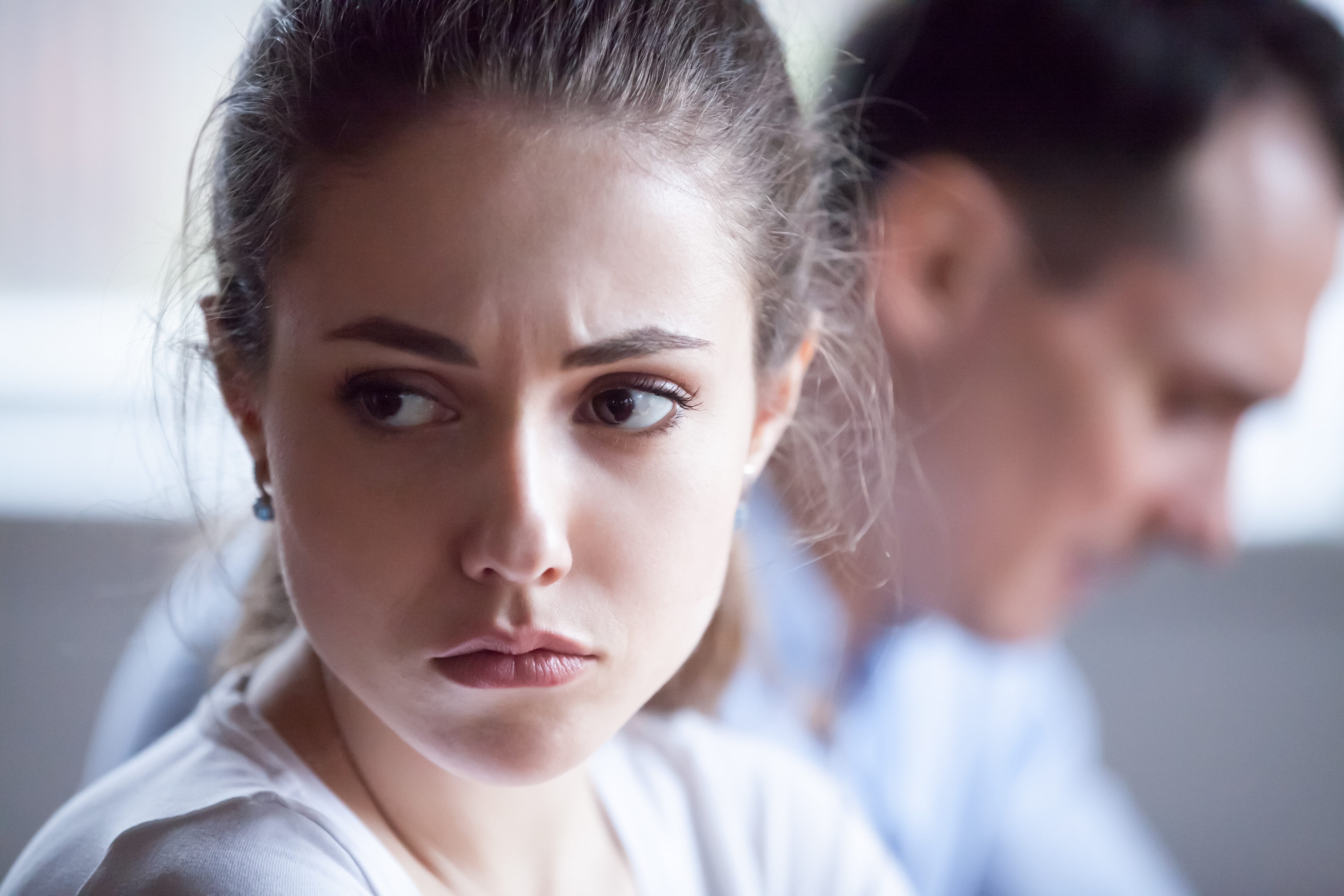 Woman looking into the distance upset as her husband sits next to her | Source: Shutterstock