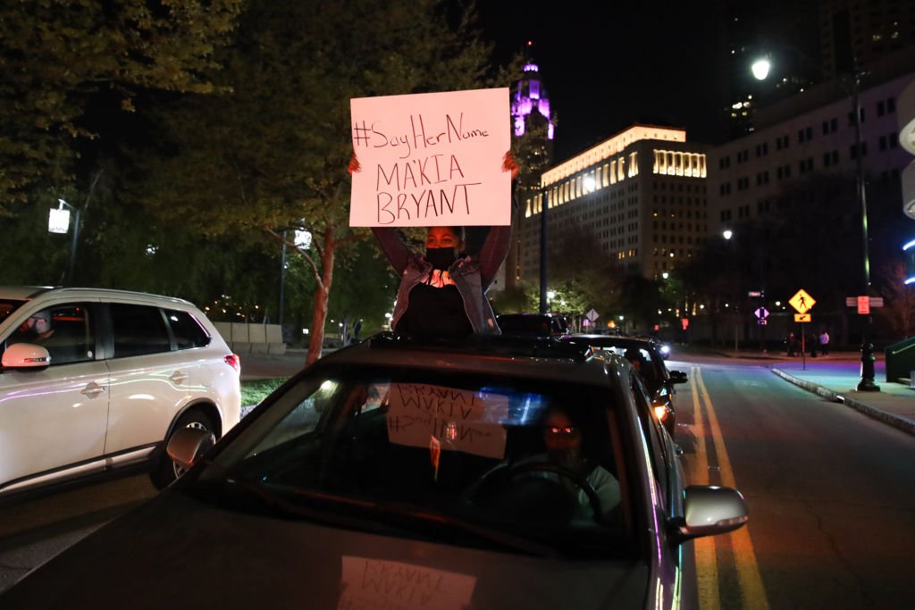 A protester holds a sign out of a car during the MaKhia Bryant protest on April 21, 2021 | Photo: Getty Images