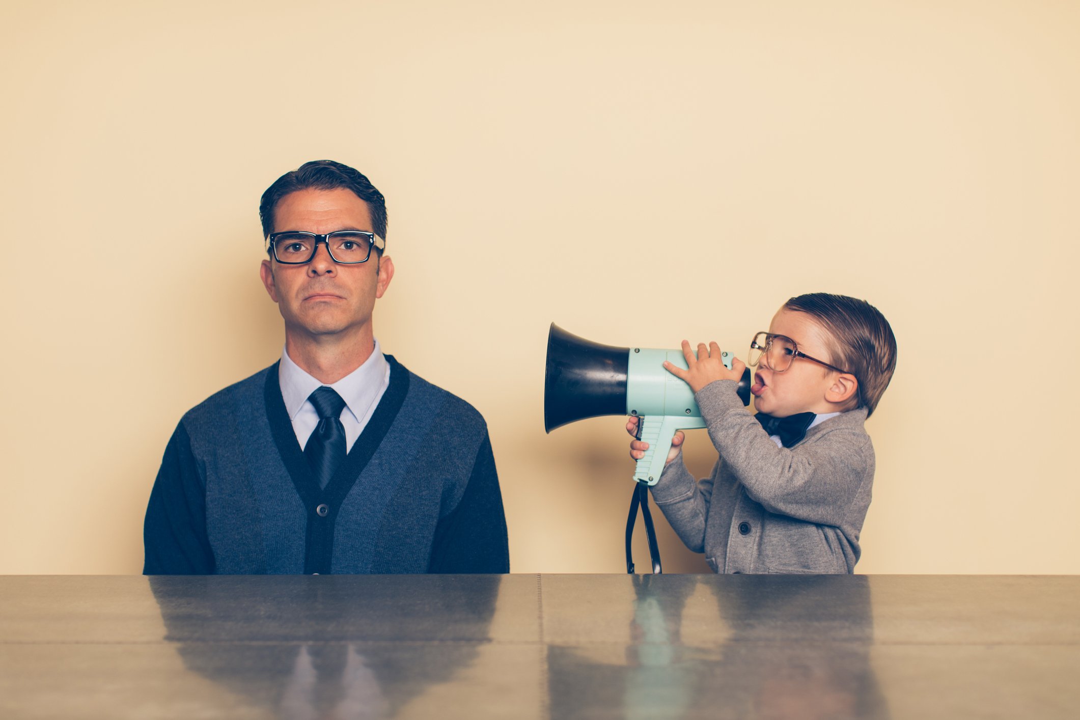 Ein Junge mit Brille schreit seinen Vater durch ein Megaphon an. I Quelle: Getty Images