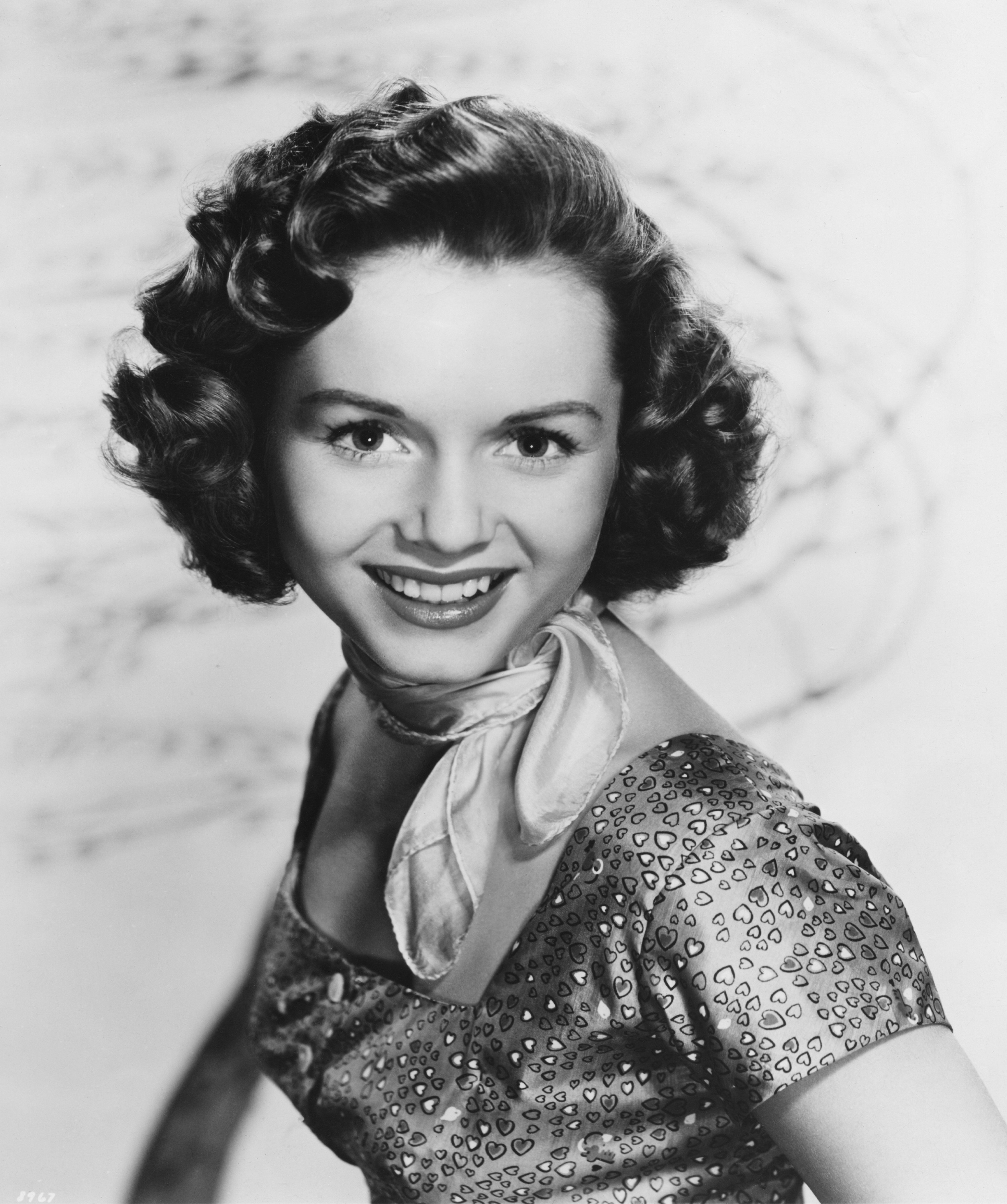 American actress Debbie Reynolds posing in a dress with neck scarf, circa 1955. | Getty Images