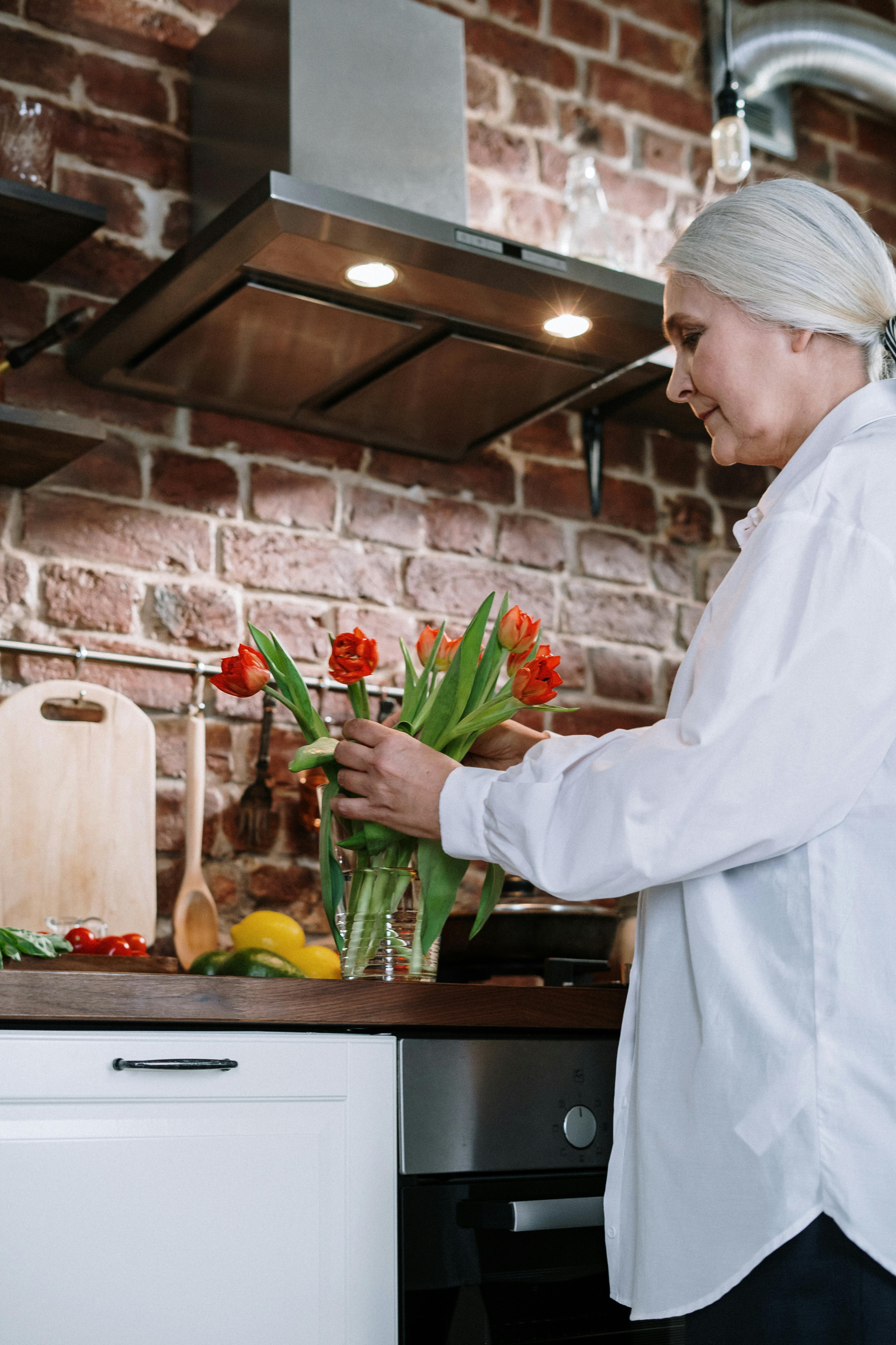 Woman arranging flowers in a vase | Source: Pexels