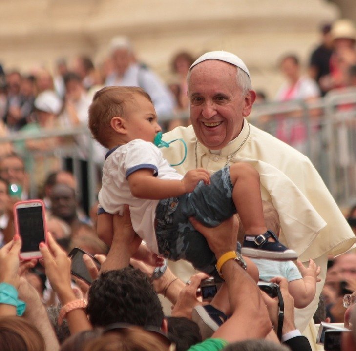 A picture of the Pope holding a child in the midst of the crowd. | Photo: Pixabay