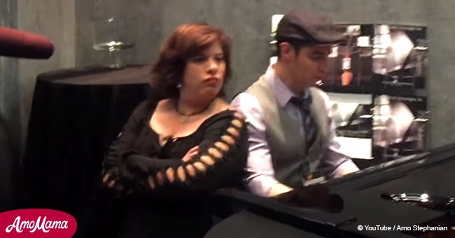 Man wows the crowd on a piano until a woman jumps in and surprises everyone