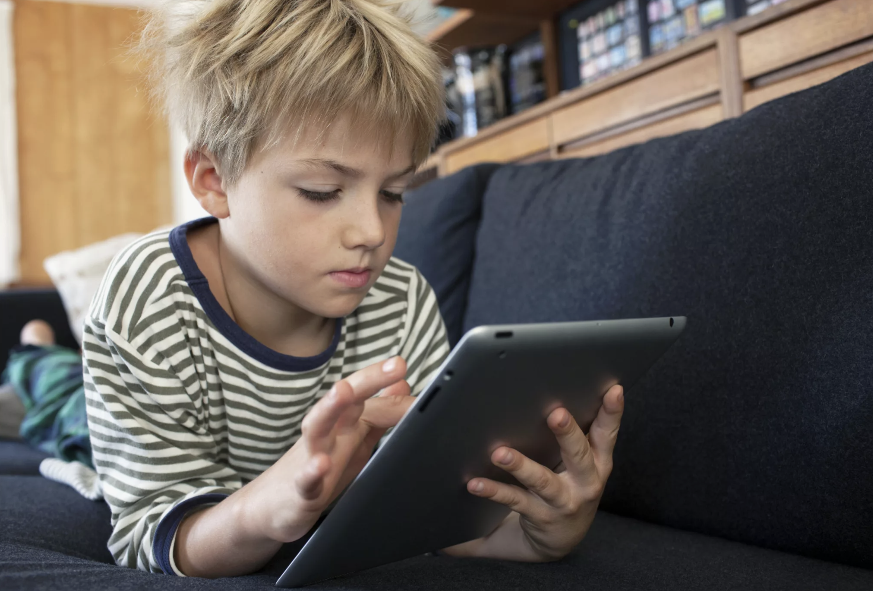 Boy engrossed in a tablet | Source: Shutterstock