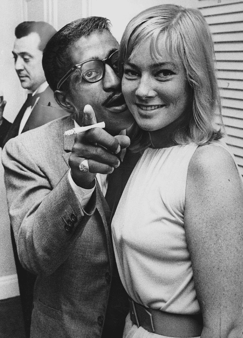 Der amerikanische Entertainer Sammy Davis Jr. (1925 - 1990) trifft seine zukünftige Frau, die schwedische Schauspielerin May Britt, wie sie aus Hollywood am Londoner Flughafen ankommt. 04.07.1960. | Quelle: Getty Images