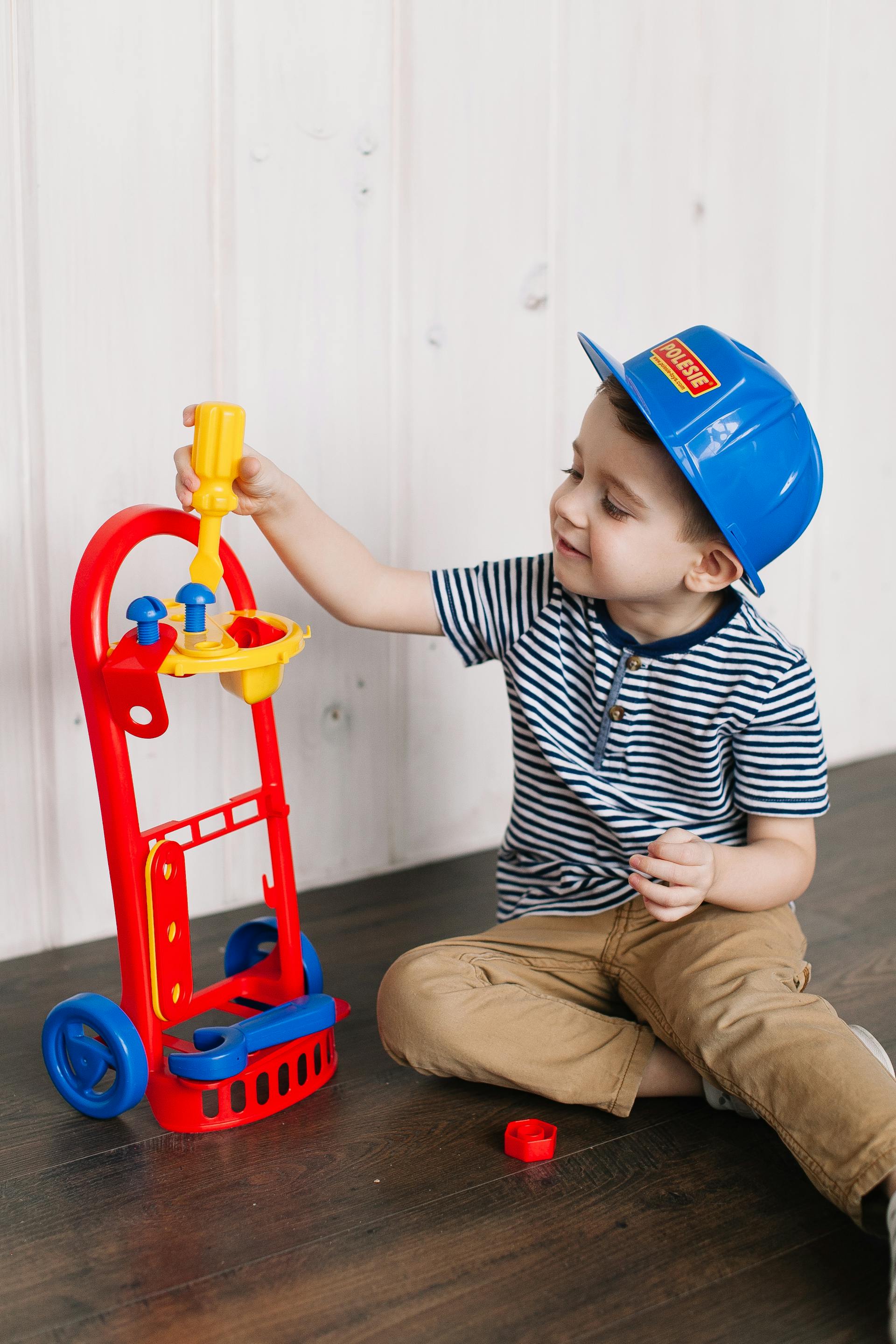 A little boy playing with a plastic screw driver toy | Source: Pexels