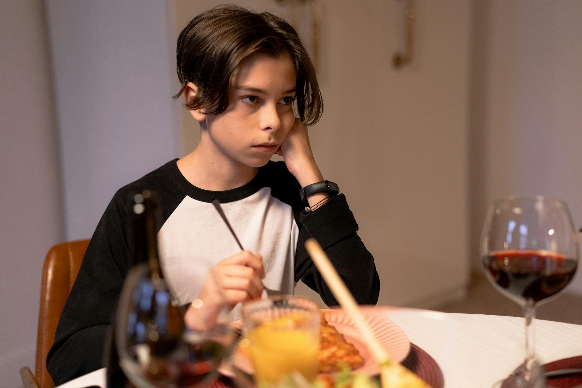 A sad boy at the dinner table | Source: Pexels