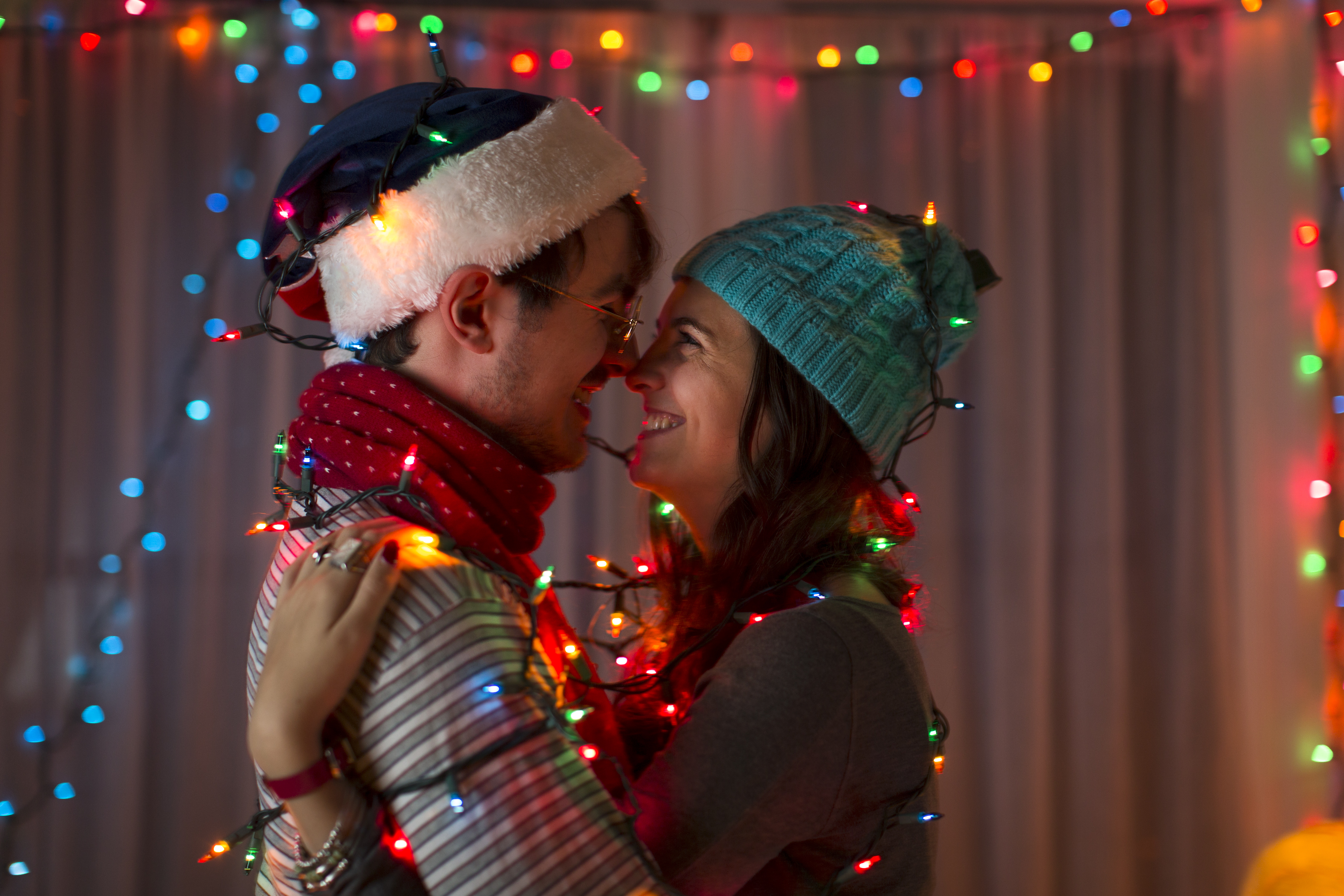 A loving couple wrapped in decorative lights on Christmas | Source: Getty Images