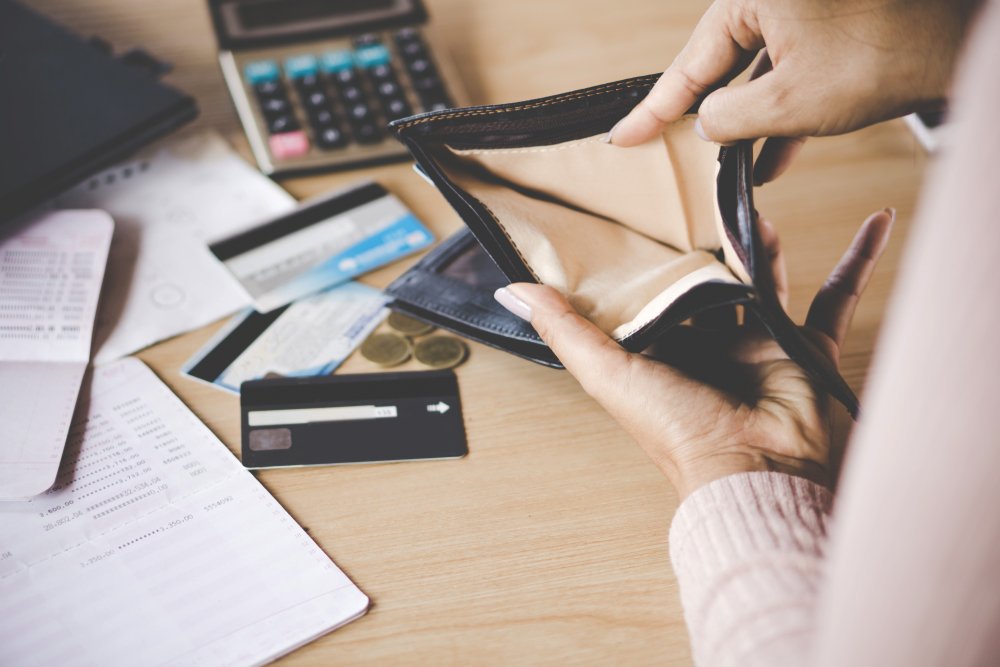 Billetera vacía y papeles de deuda. | Foto: Shutterstock