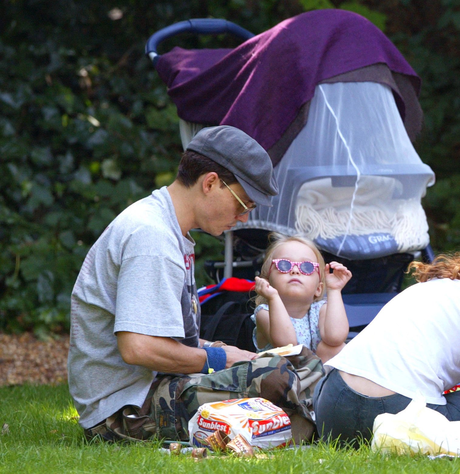 Johnny Depp y su esposa, Vanessa Paradis, llevan a sus dos hijos a un picnic en un parque de Londres, el 14 de julio de 2002. | Foto: Getty Images